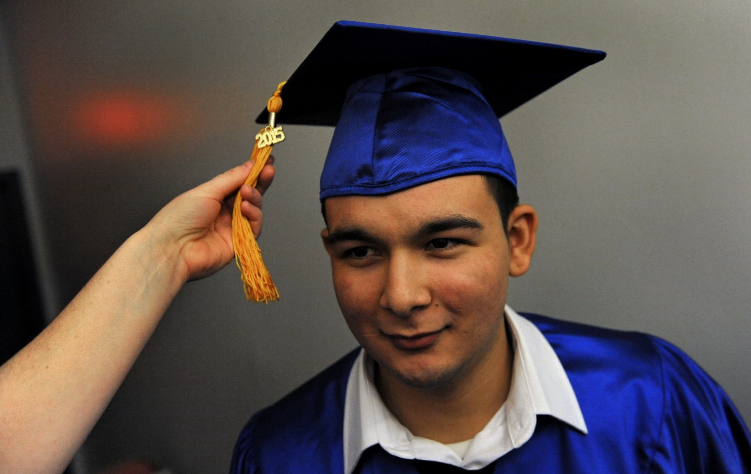 Next Step grad Guillermo Romero plans to go on to college. Adjusting his tassel is Lily Harris, a staffer at Next Step. The District is considering a proposal to give diplomas to GED recipients. (Michael S. Williamson/The Washington Post)
