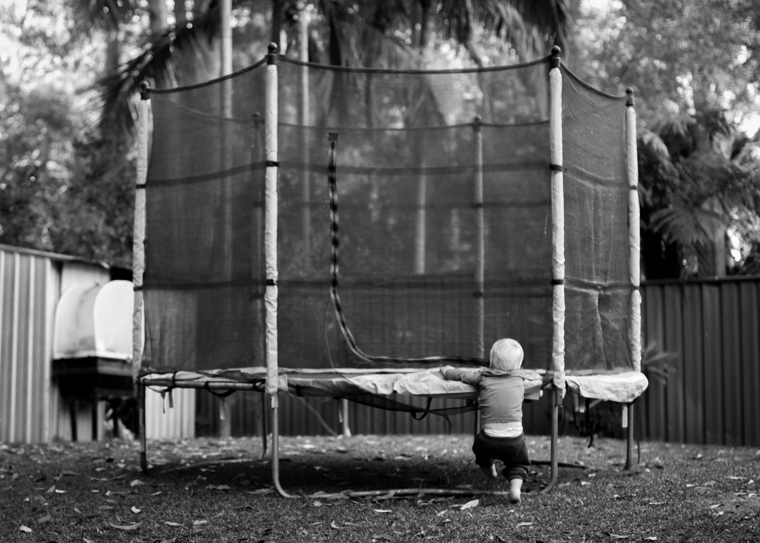 toddler trying to climb onto trampoline