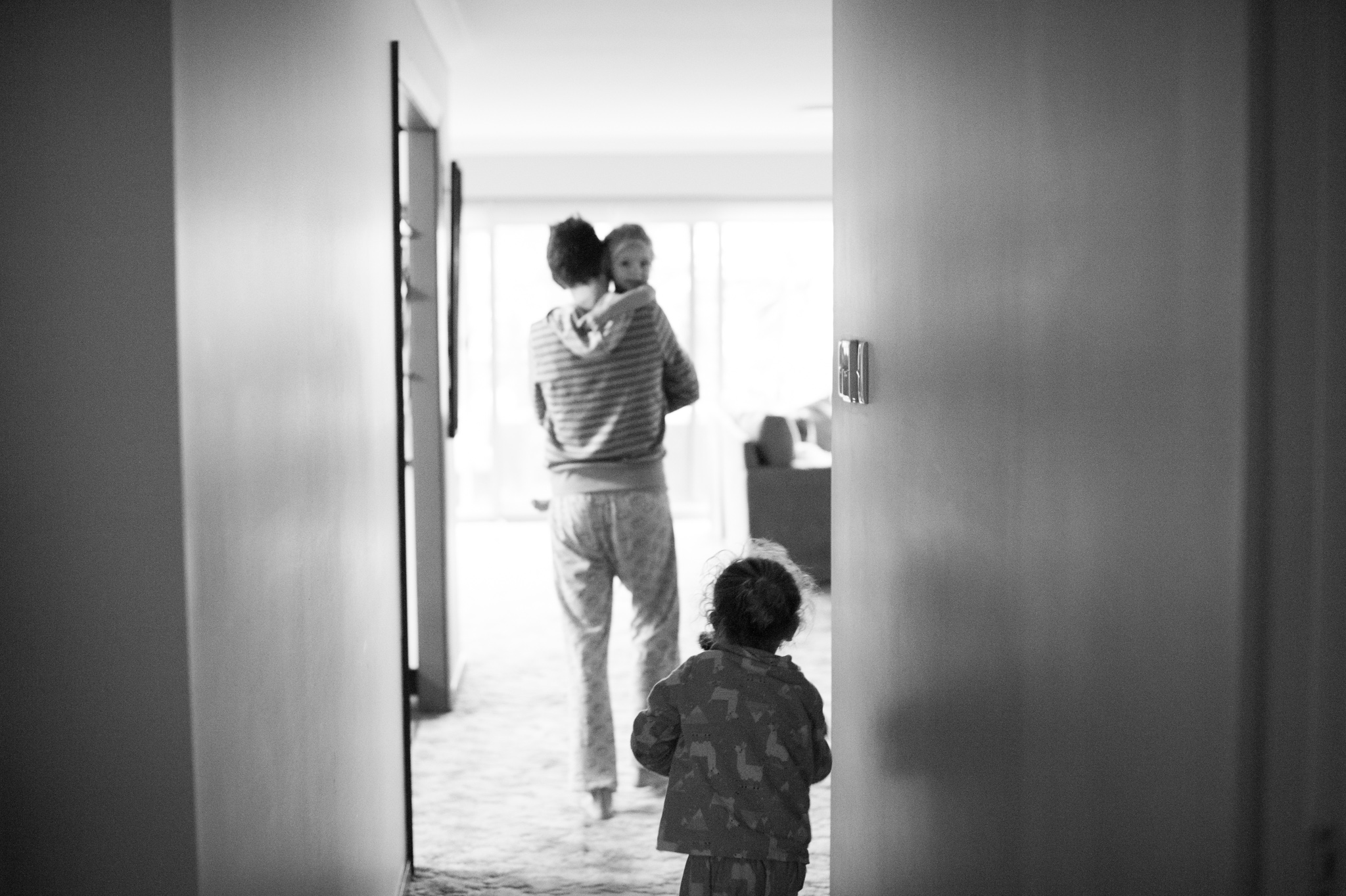 Mummy carrying daughter in hallway