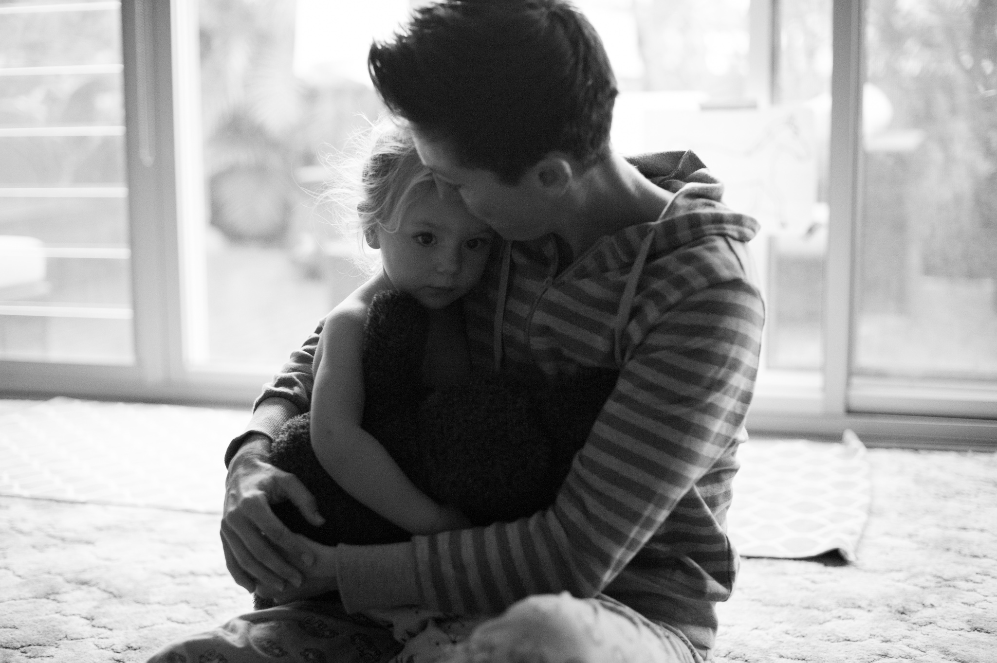 Mummy cuddling daughter with teddy bear