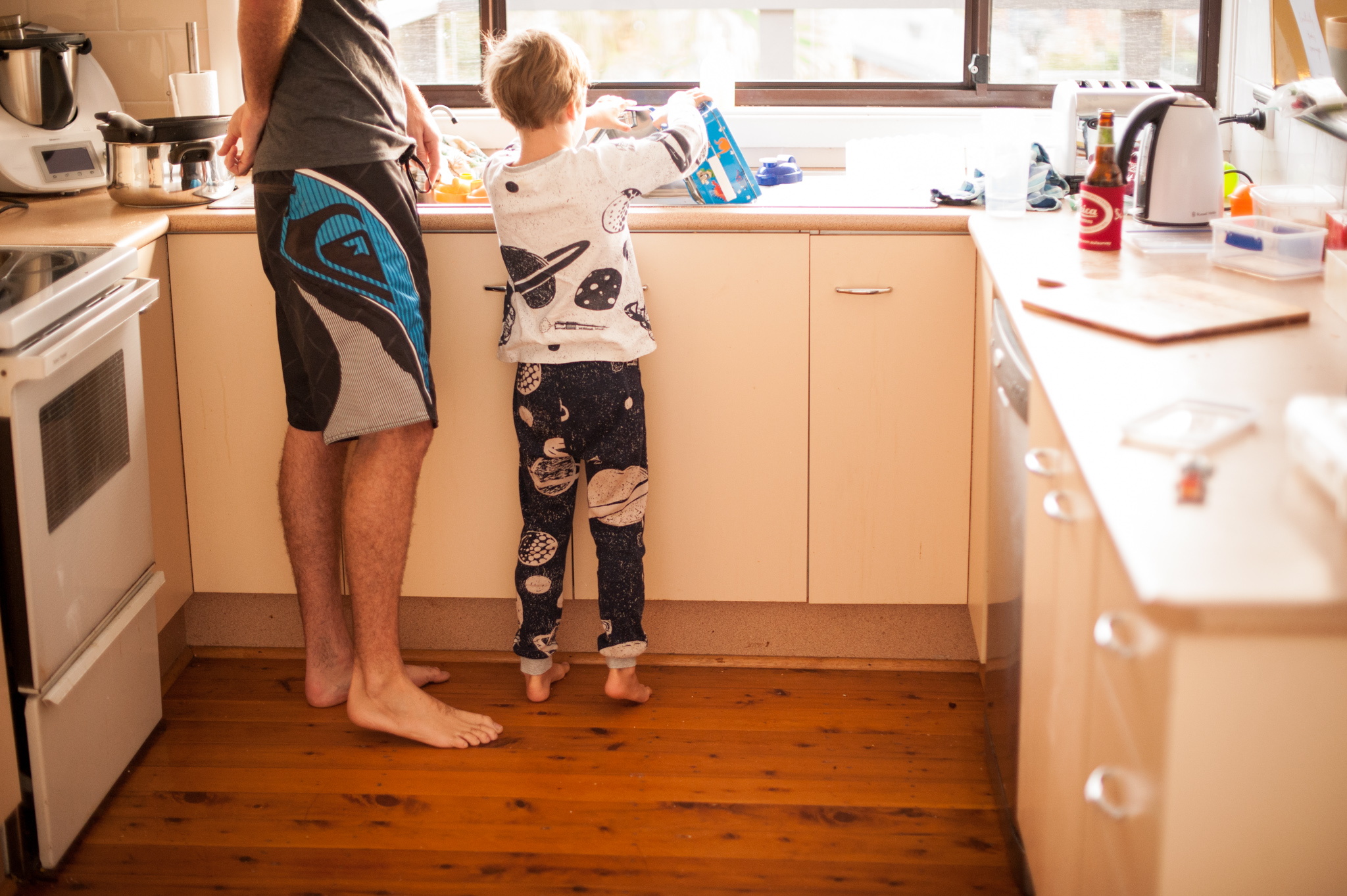 Father and son washing the dishes at the kitchen sink