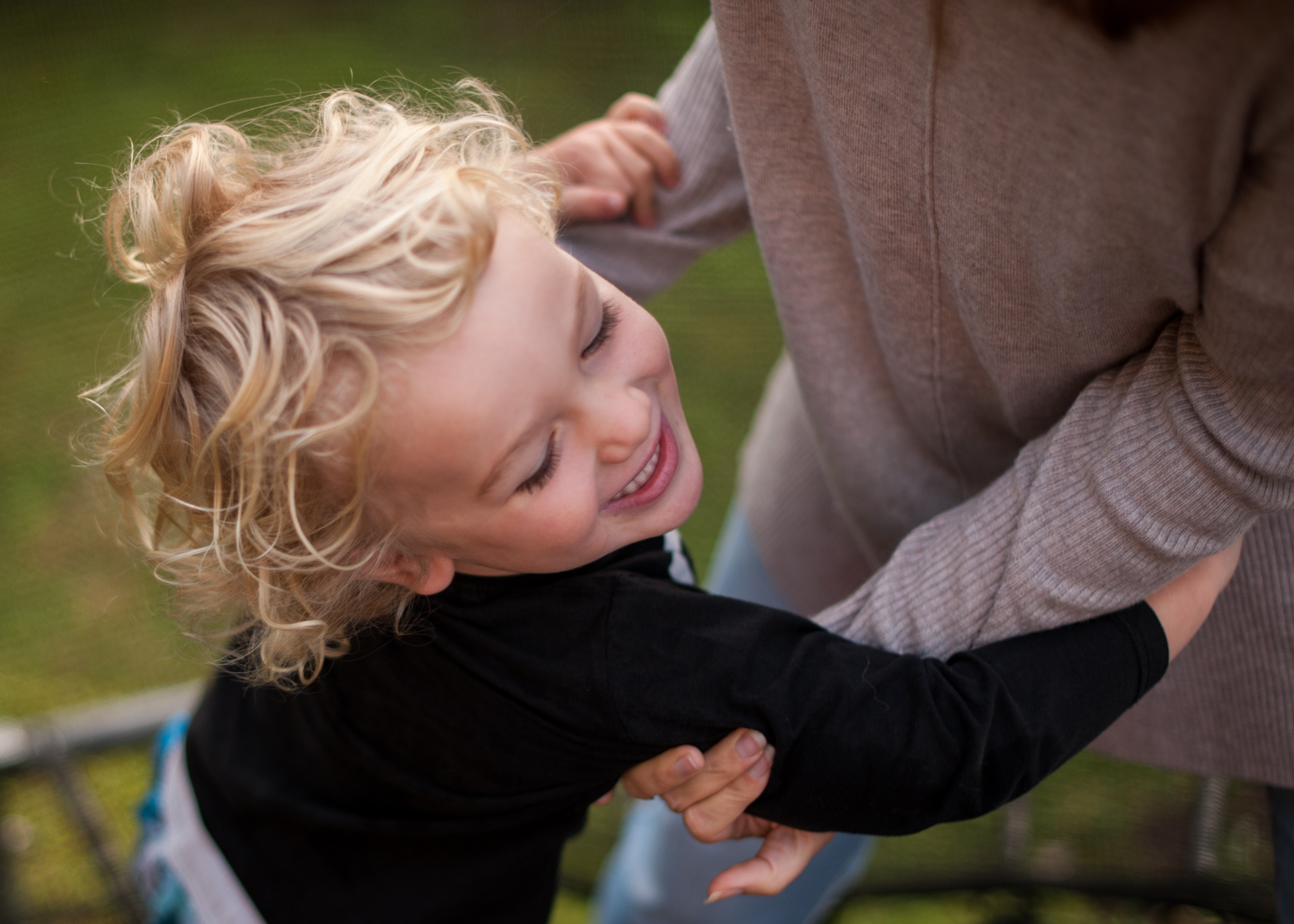 Mummy playing rumbles with son on trampoline