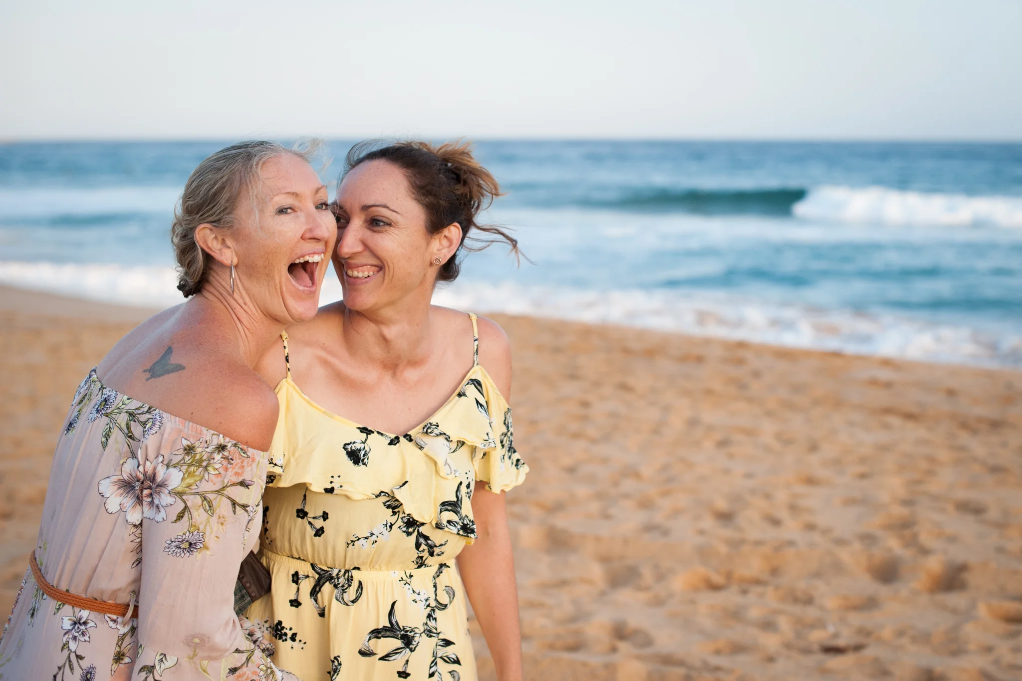 central coast family photographer sisters laughing on the beach
