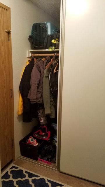 Hallway closet with a long storage area behind the coats