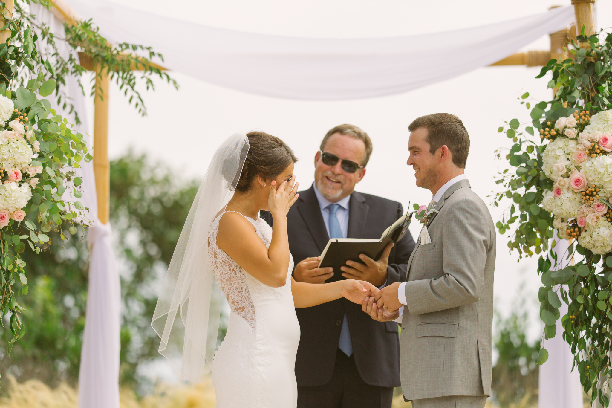 Bride and groom exchange vows at San Diego, California outdoor wedding planned by Exhale Events. See all the beautiful details at exhale-events.com!