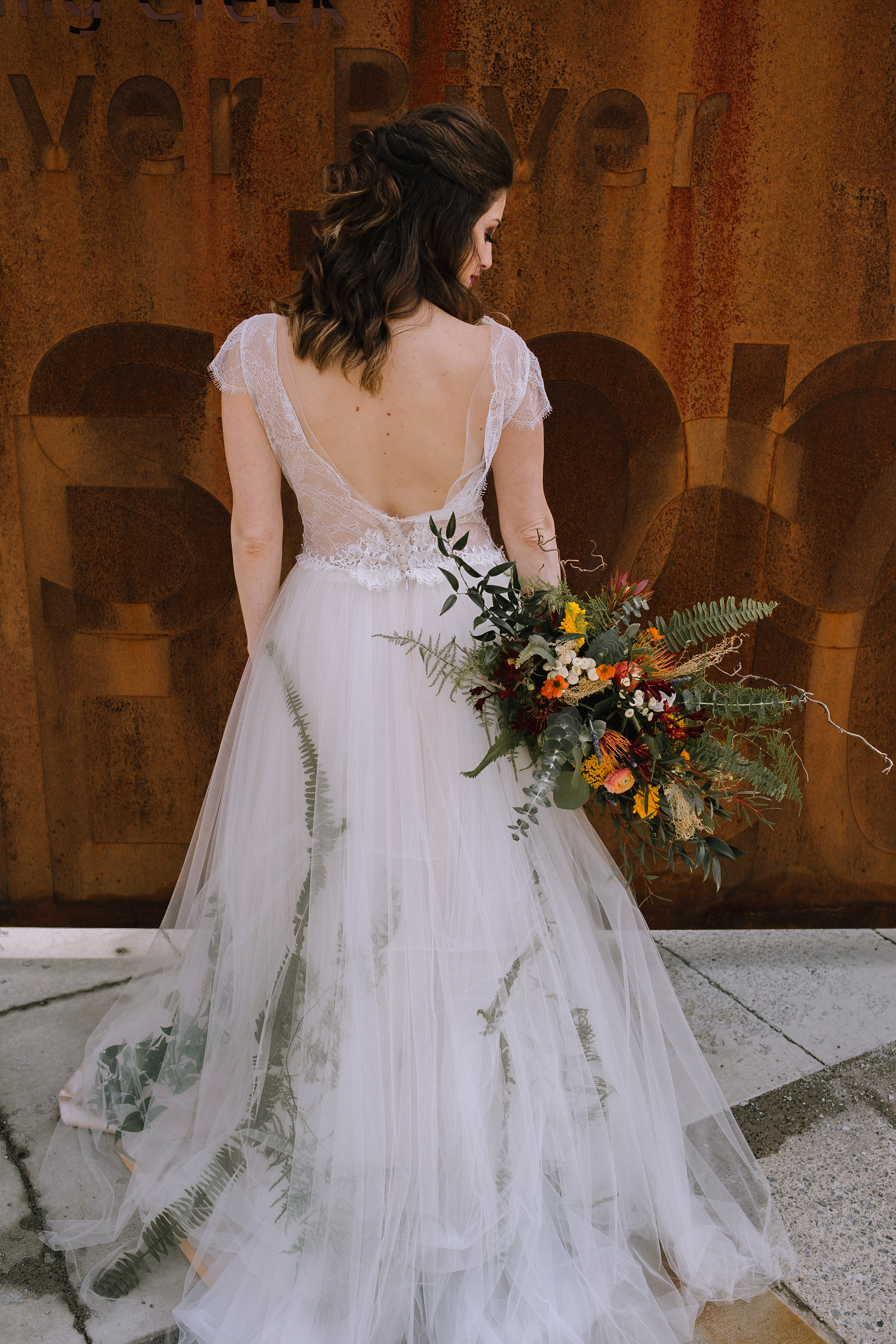 Boho bride poses with wedding bouquet for fall vintage boho styled shoot designed by exhale events. Get inspired by these gorgeous wedding details at exhale-events.com!