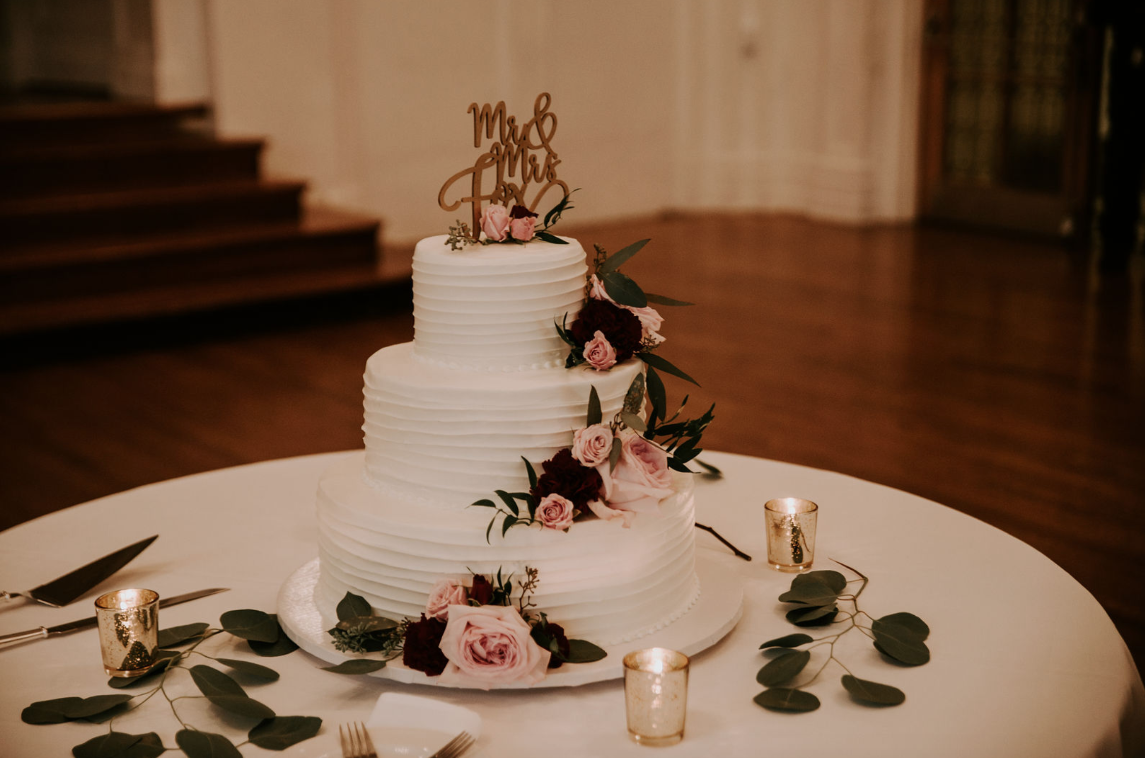 Wedding cake with flowers and gold wedding topper at Buffalo, NY wedding planned by Exhale Events. Find more wedding inspiration at exhale-events.com!