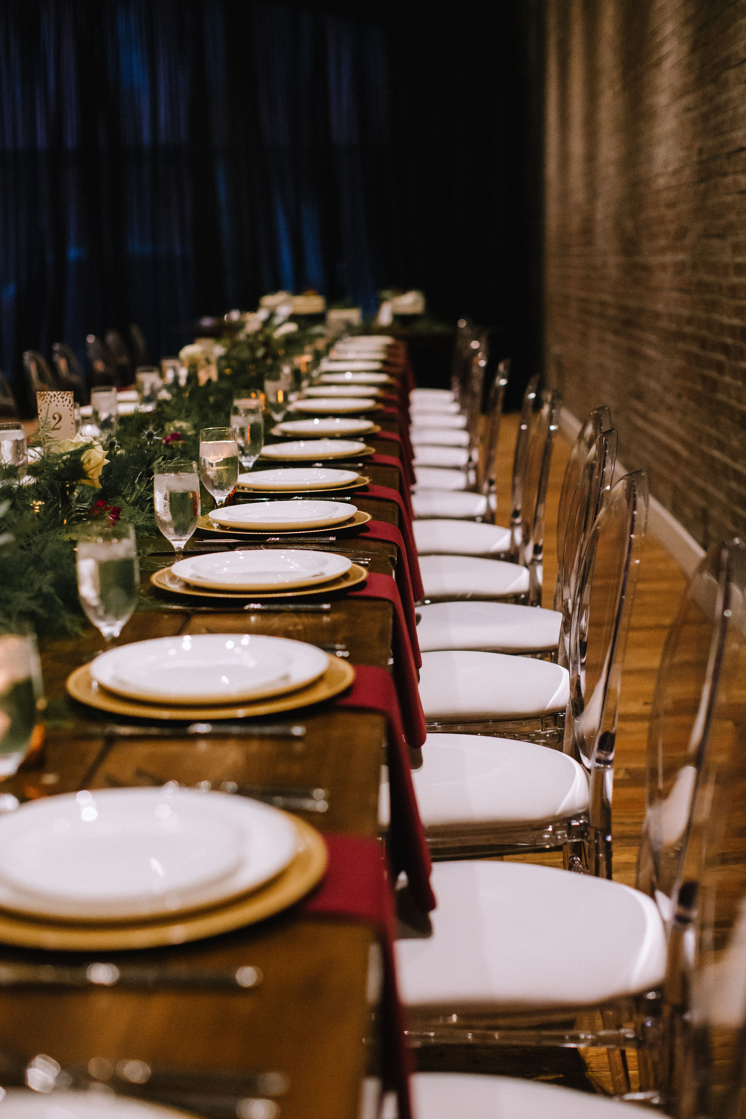 Wedding table setting and table decor with greenery and red and gold accents for Pittsburgh wedding at Studio Slate planned by Exhale Events. Find more wedding inspiration at exhale-events.com!