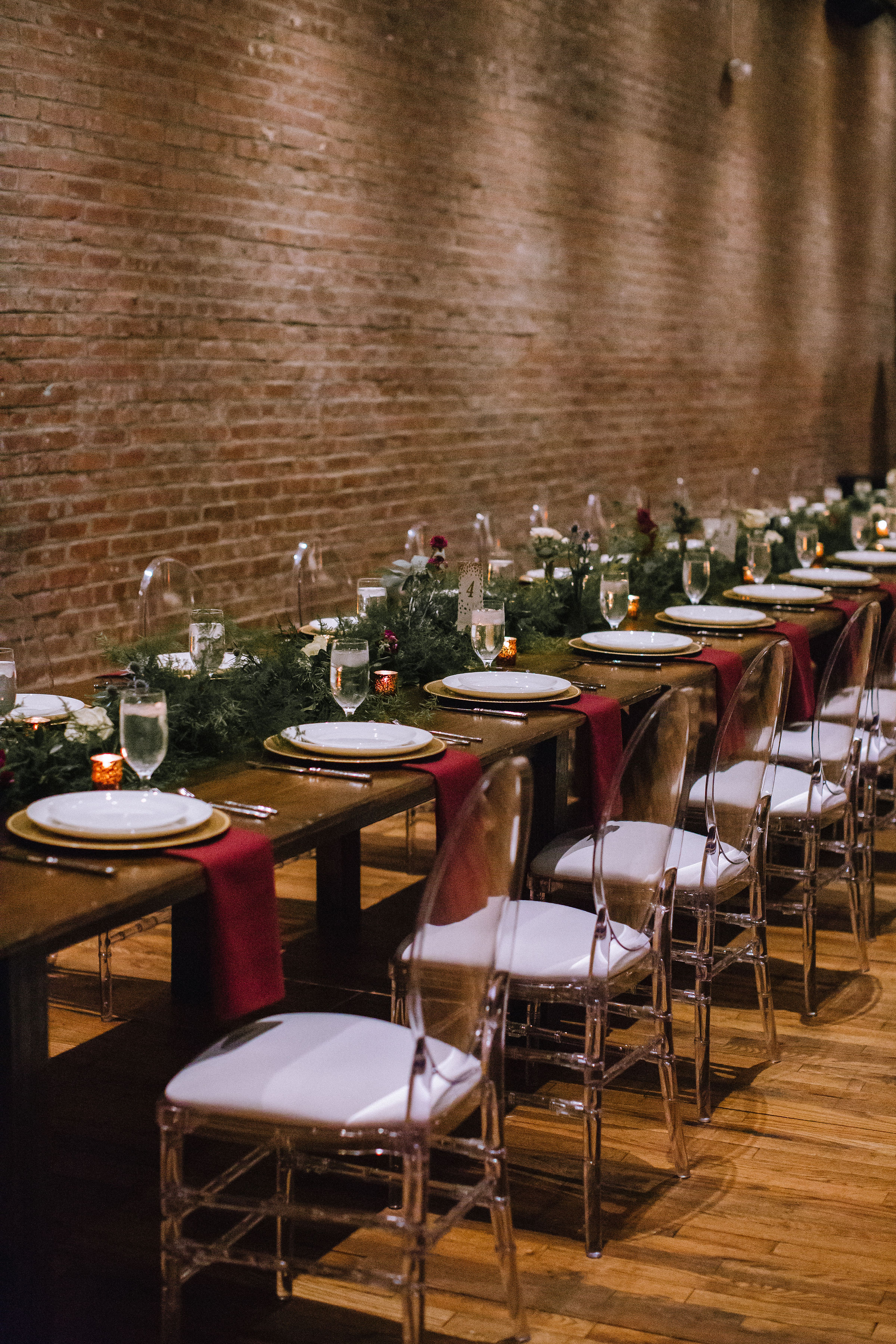 Wedding table setting and table decor with greenery and red and gold accents for Pittsburgh wedding at Studio Slate planned by Exhale Events. Find more wedding inspiration at exhale-events.com!