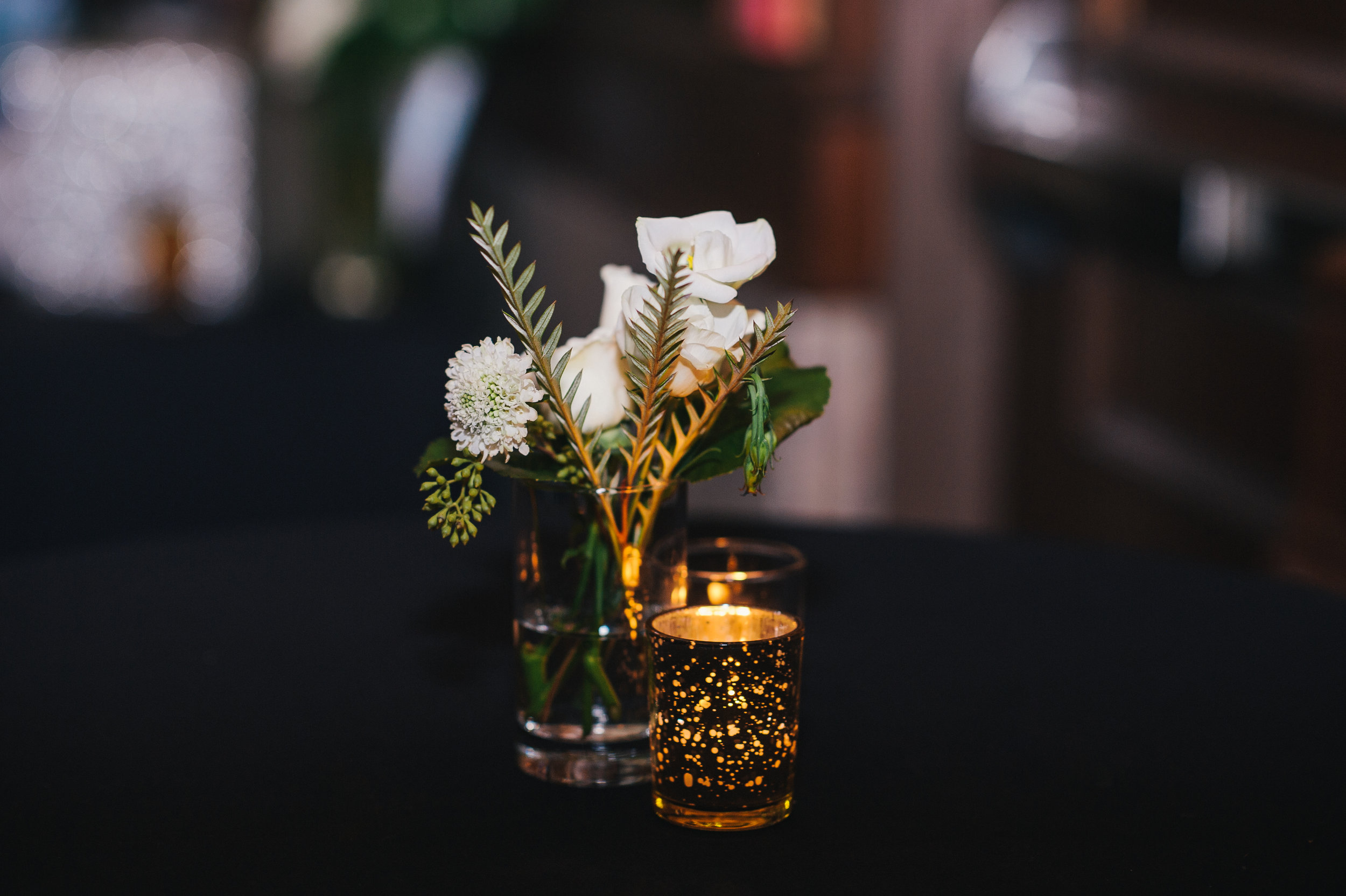 White wedding flower centerpieces with candles for black, white, and gold wedding in Buffalo, NY planned by Exhale Events. Find more wedding inspiration at exhale-events.com!
