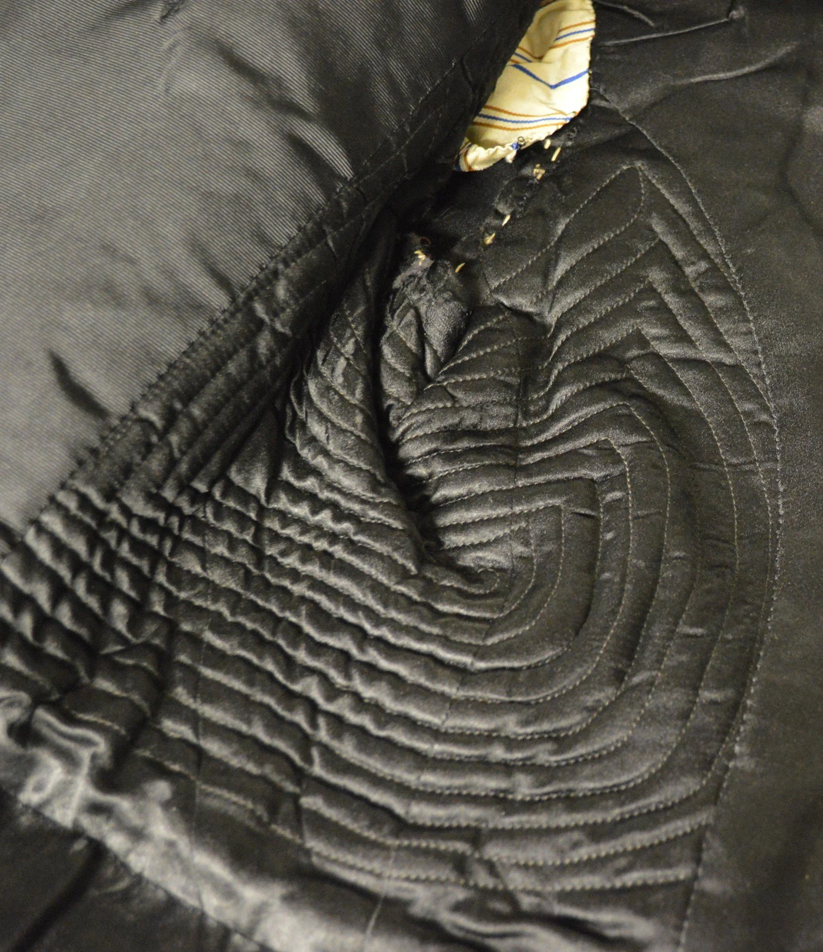 An interior view of the Black Creek tailcoat, where close stitching in a whorl or spiral pattern is visible on the underarm lining.