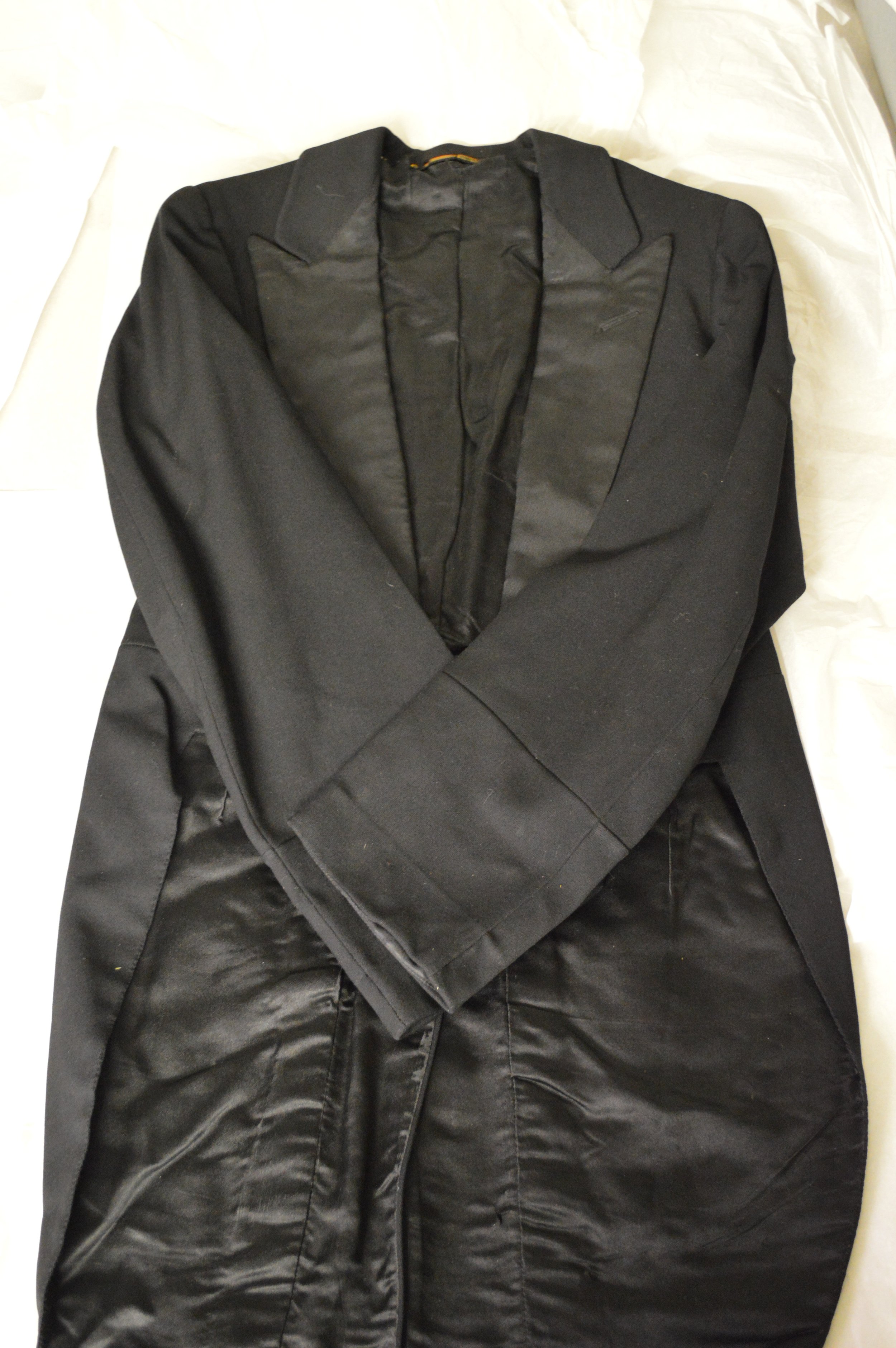The Black Creek tailcoat is laid flat on a table, with its arms crossed over the centre.