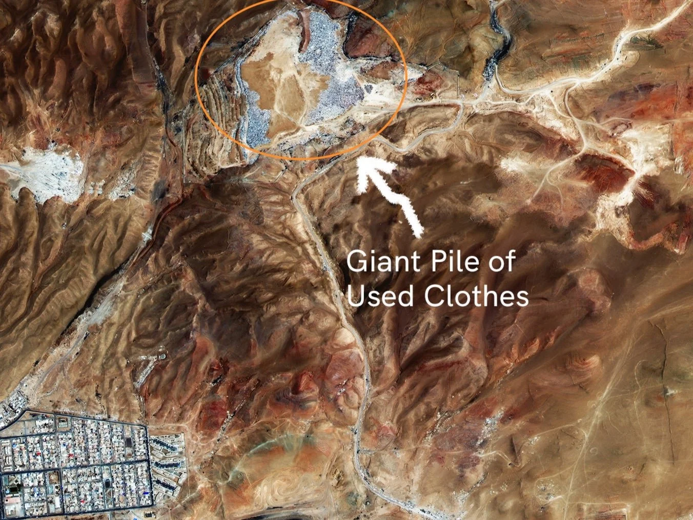 A satellite image shows vast, brown and red coloured land. The text “Giant Pile of Used Clothes” is in white, and a white arrow points from the text to an orange circle.