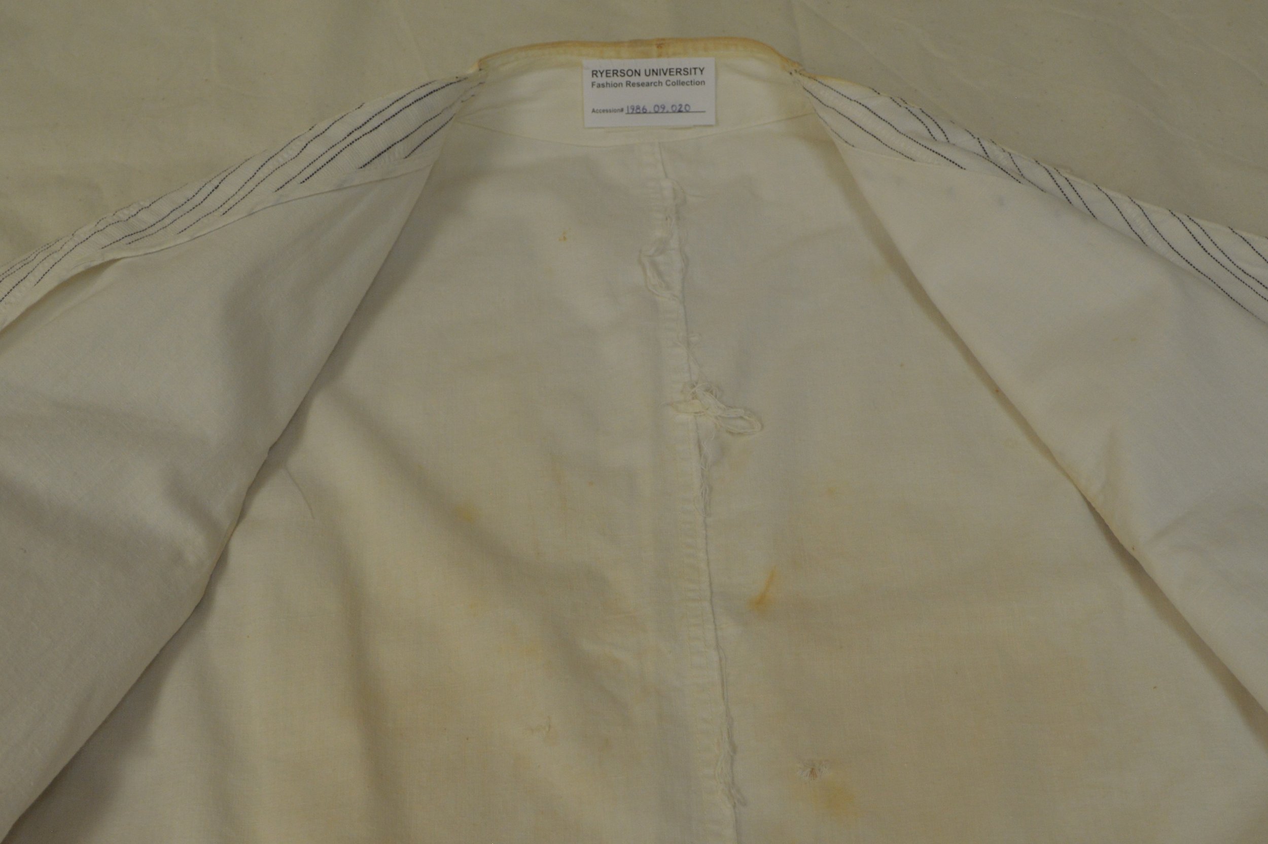 An interior view of the pinstripe vest from the FRC, where the fraying on the interior seam is visible.