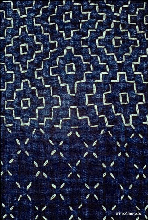 Sashiko mending with repeating white stitching patterns on indigo fabric