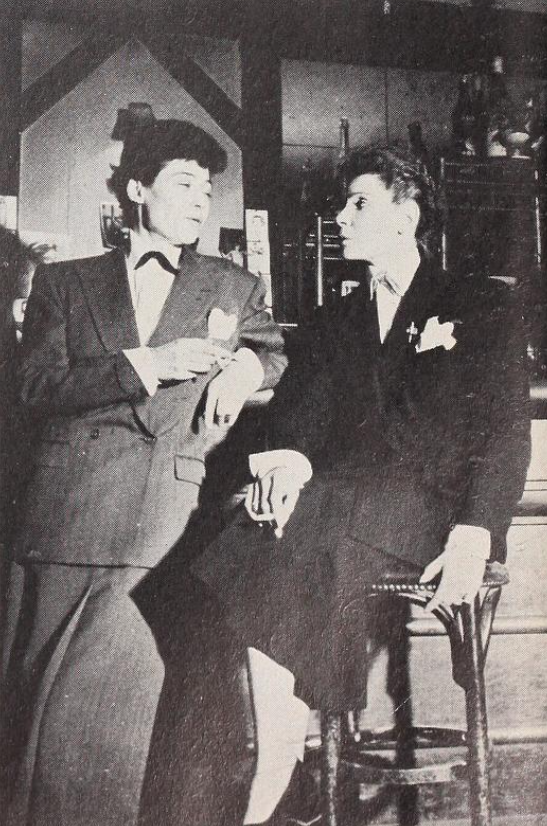 Owner of Elle et Lui Frede Baule standing wearing a long skirt and matching blazer next to the secretary of the club Michele Berger wearing a similar ensemble and matching short hair.