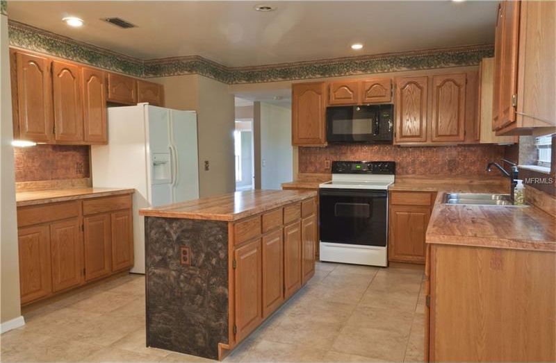 The kitchen when we moved in. Good bones - lots of brown.