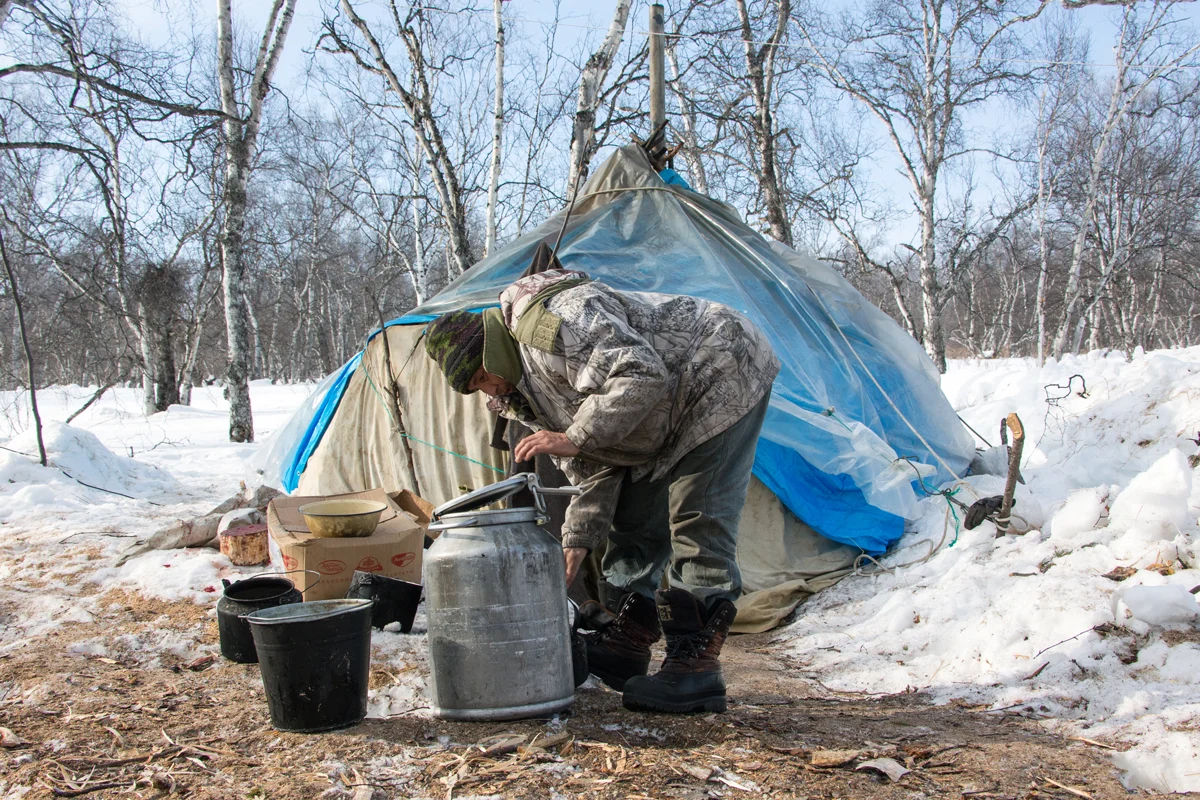One of the reindeer herders refills the water kettle outside the yurt. Photo: Matt Reichel. 