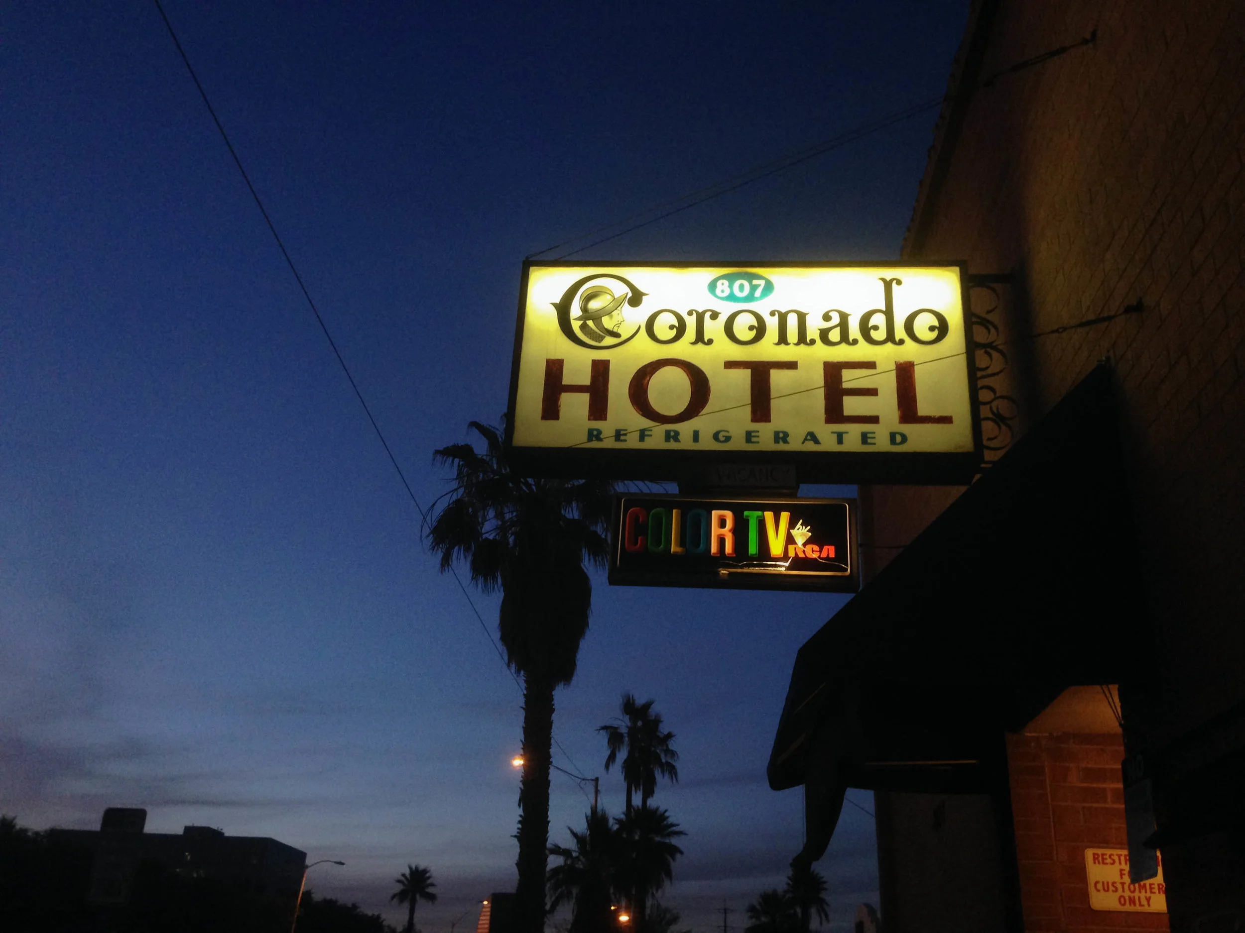 A hotel sign glows as dusk falls in downtown Phoenix. 