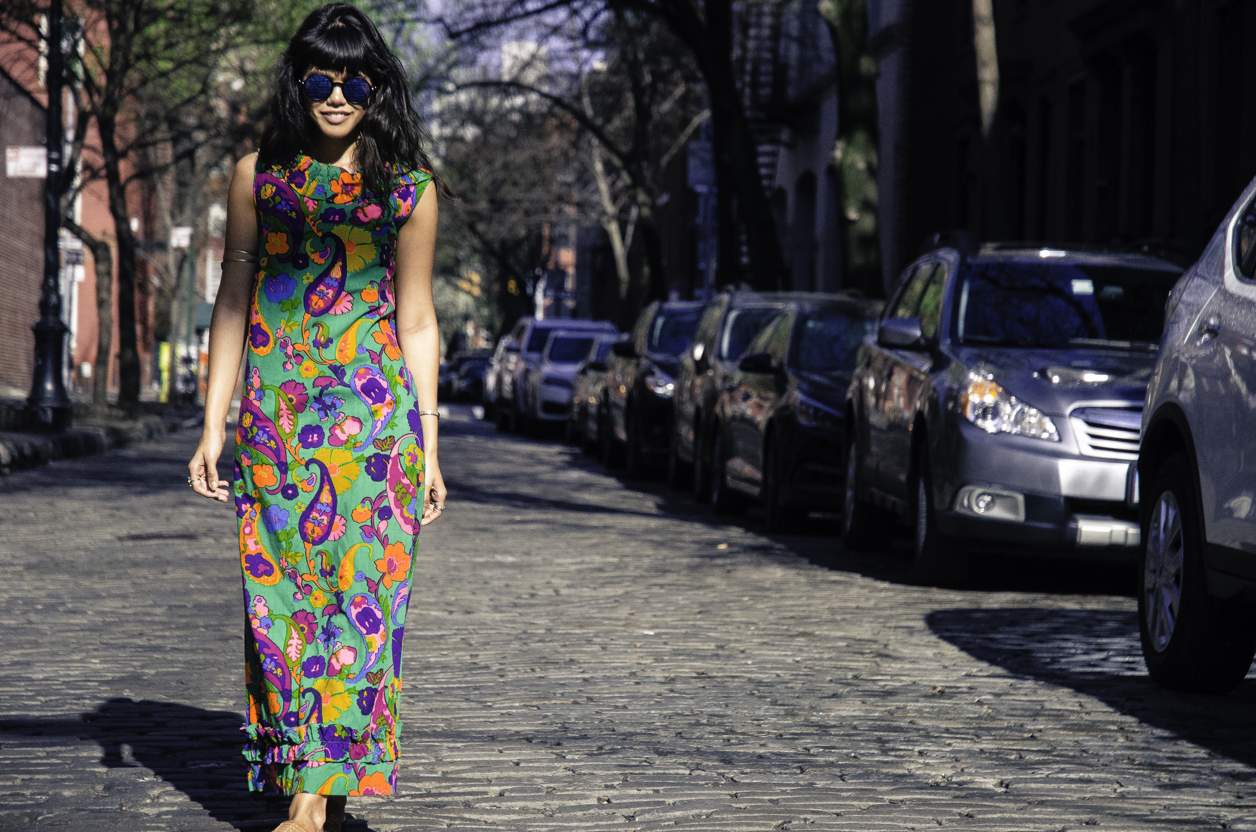 Meg Vice embodies 70s psychedelic style by wearing a vibrant floral and paisley dress. 