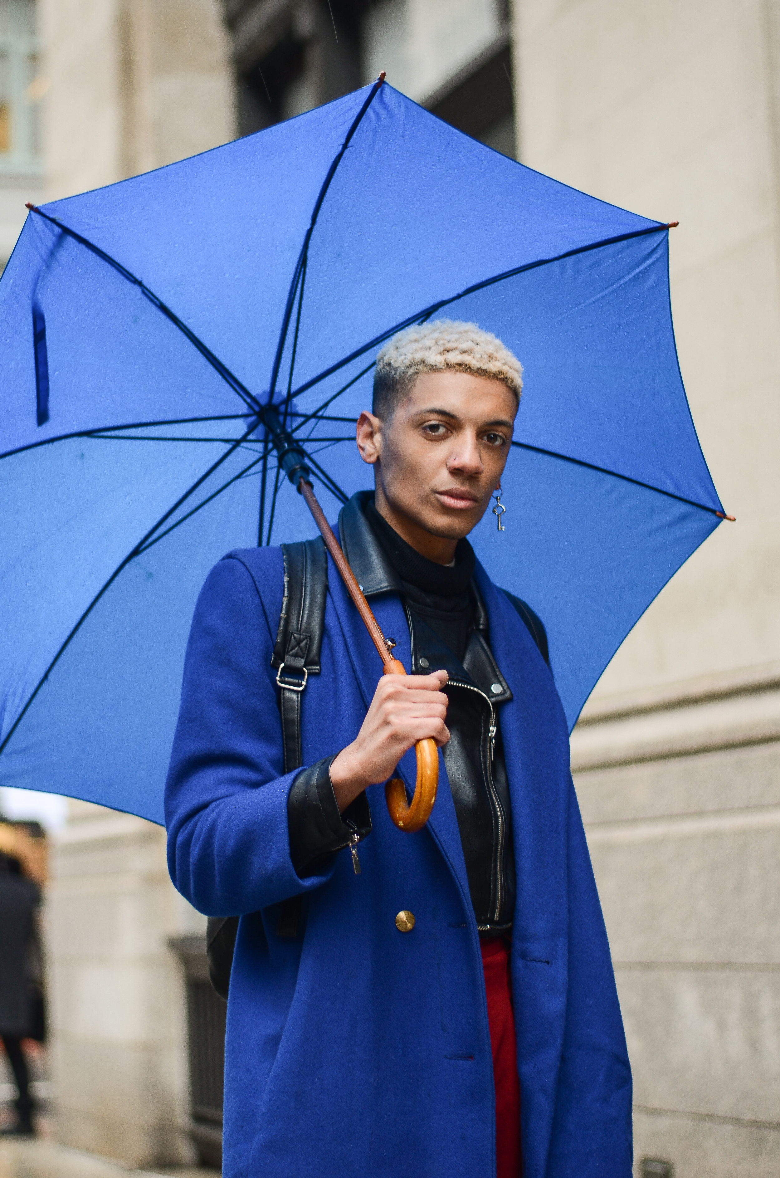 A strong dichotomy between the sophisticated use of blue, and the edgy elements of his hairstyle, earring, and leather jacket.