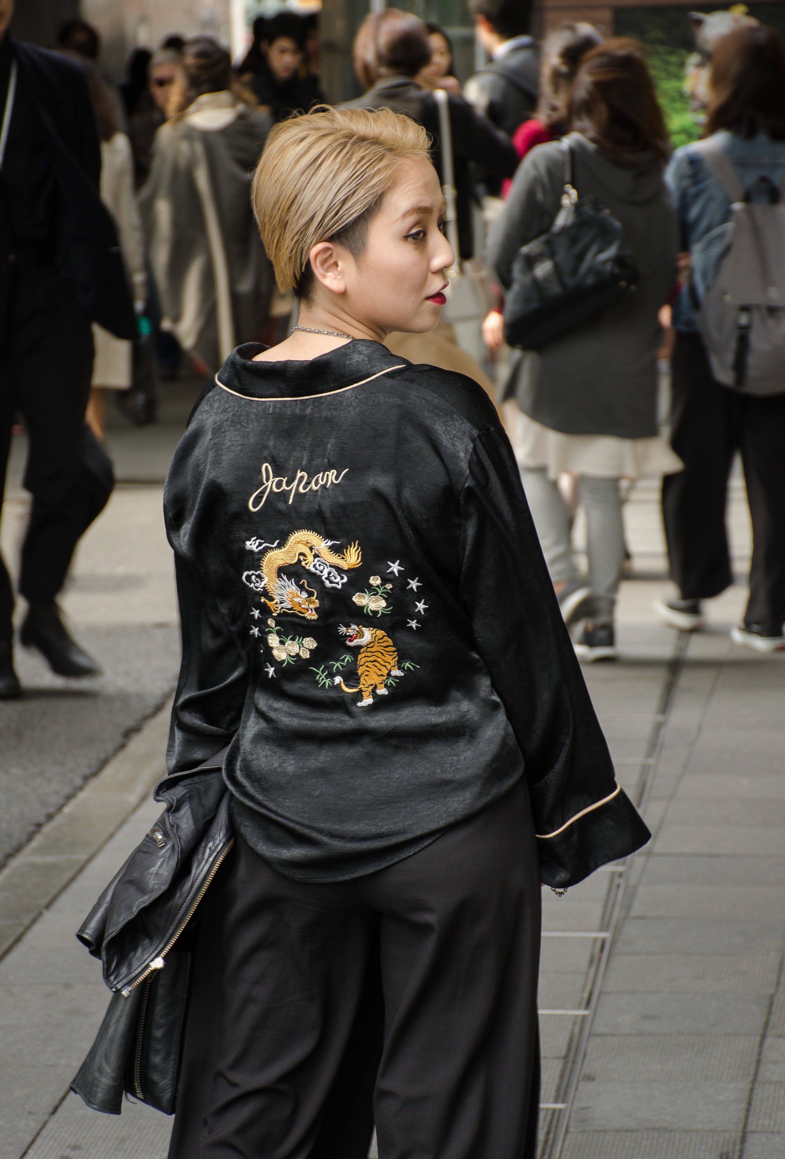 There is irony in her outfit: The foundation is black, but the back design features the animals symbolic of yin (the tiger), and yang (the dragon). Rarely does an outfit carry such philosophical complexity. (日本語のキャプション: 哲学的な服は珍しい。このイメージで何が理解できるの?五行?自然の円満? )