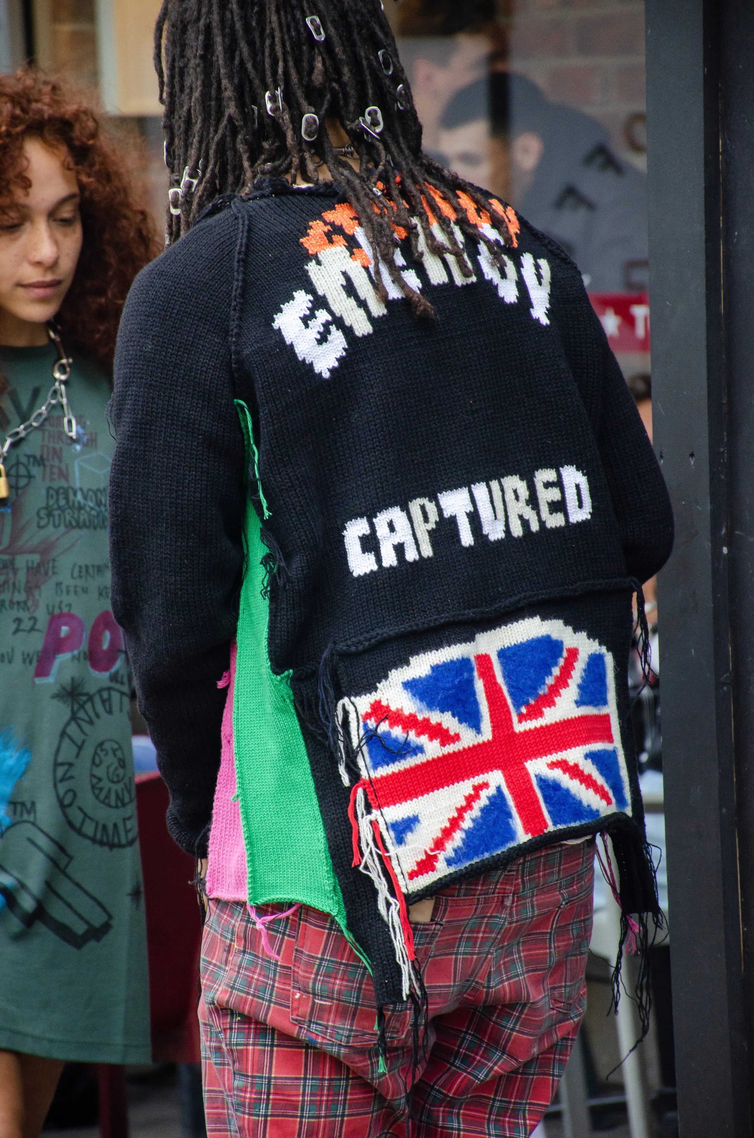 It takes a creative mind to use soda-can openers as hair accessories, and sport scribbled-on Timberland boots. Indeed, he and his outfit are “captured” in a reality of his own making.