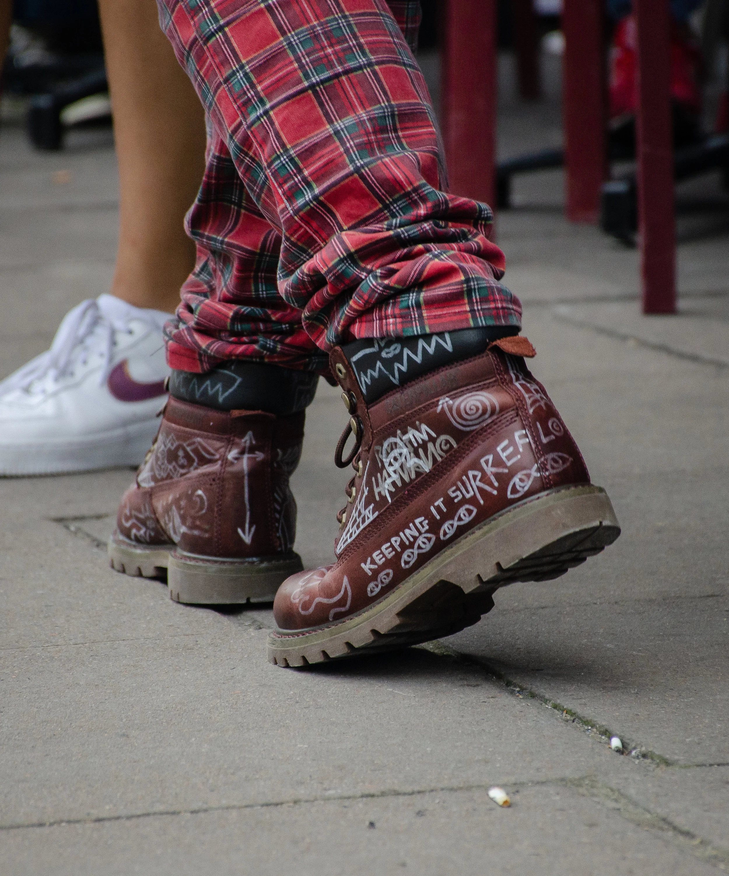 It takes a creative mind to use soda-can openers as hair accessories, and sport scribbled-on Timberland boots. Indeed, he and his outfit are “captured” in a reality of his own making.