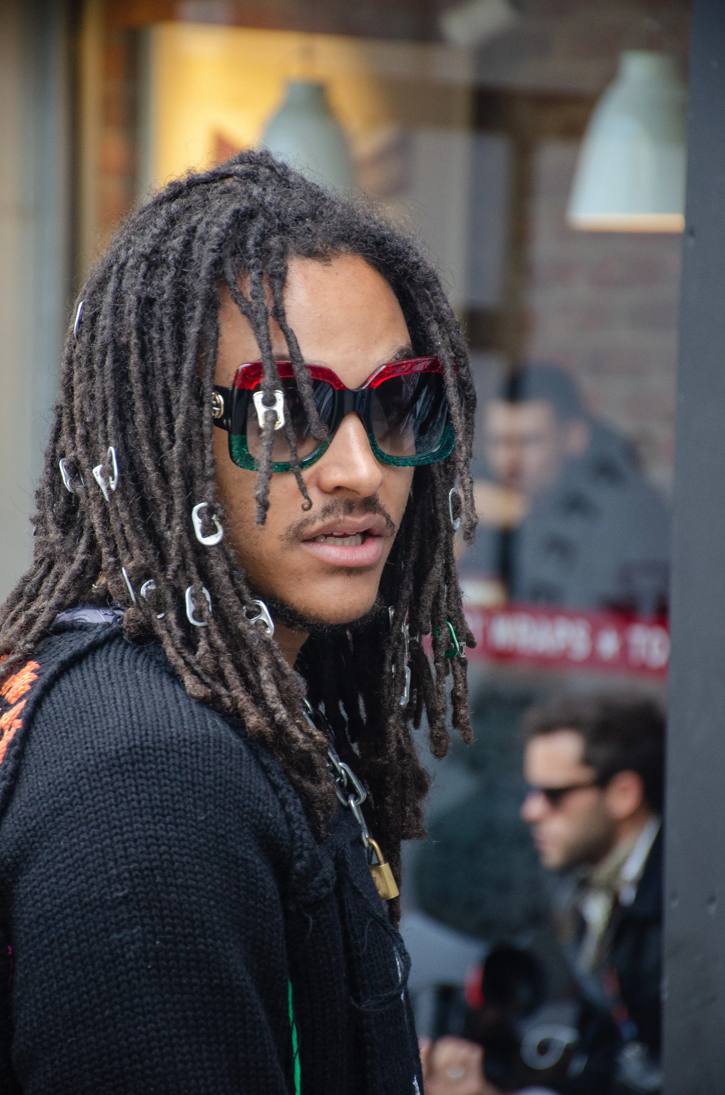 It takes a creative mind to use soda-can openers as hair accessories, and sport scribbled-on Timberland boots. Indeed, he and his outfit are “captured” in a reality of his own making.