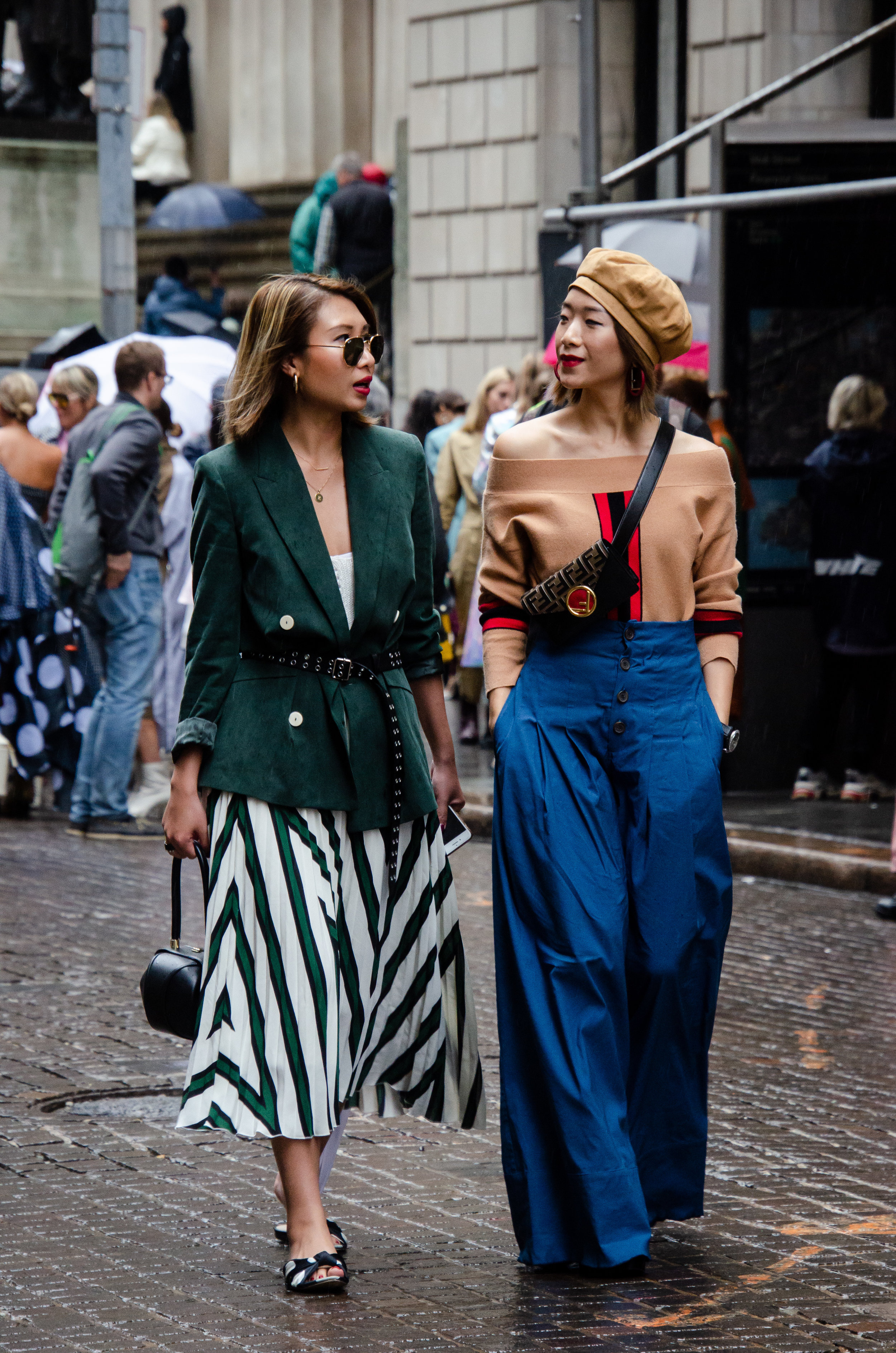 Asymmetrical reflection: Whereas each outfit is of its own persona and color story, these two fashion-forward individuals share the same effortless demeanor.