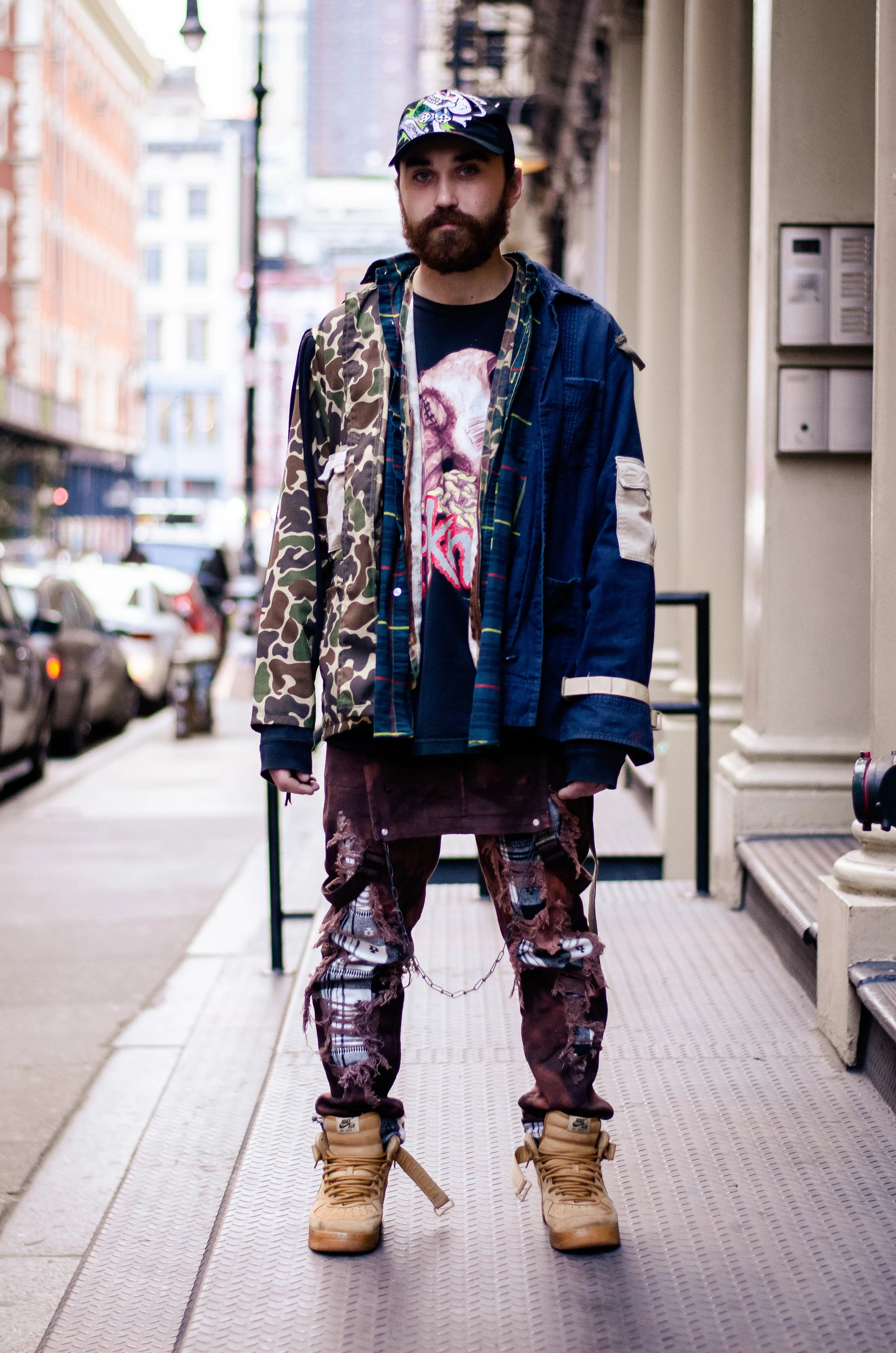When in doubt, create your own statement pieces, right? Emmett creates his own pieces with clothing found at thrift stores, and flea markets. His jacket is made from camo-print, plaid, and chambray fabrics. Moreover, he dyed and distressed his overalls. The resulting look can be described as experimental grunge