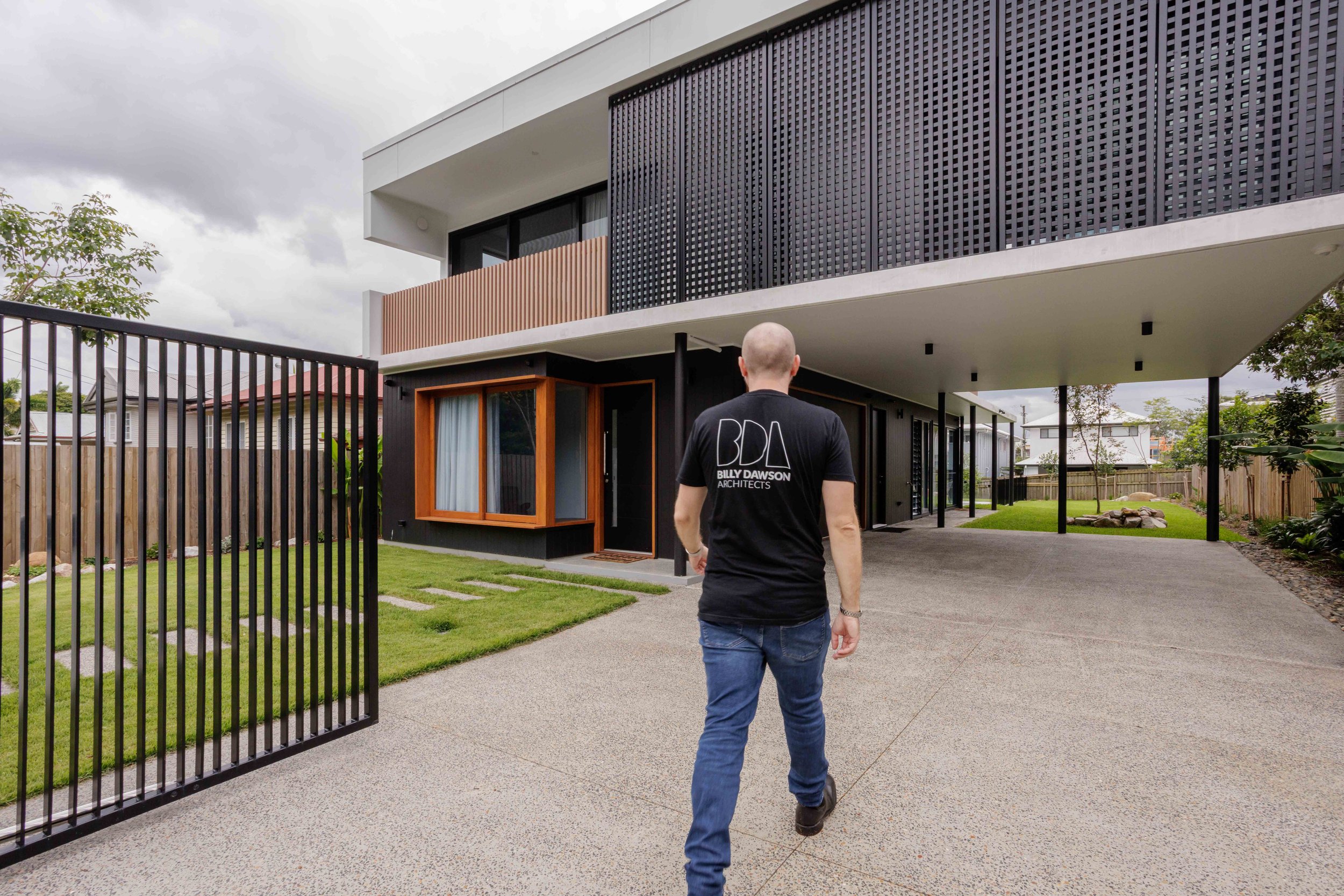 Bill Dawson Architects owner walking onto one of his finished projects in BrisbaneBrisbane architectural photography, exterior facade with natural light and shadow detail — Billy Dawson Architects