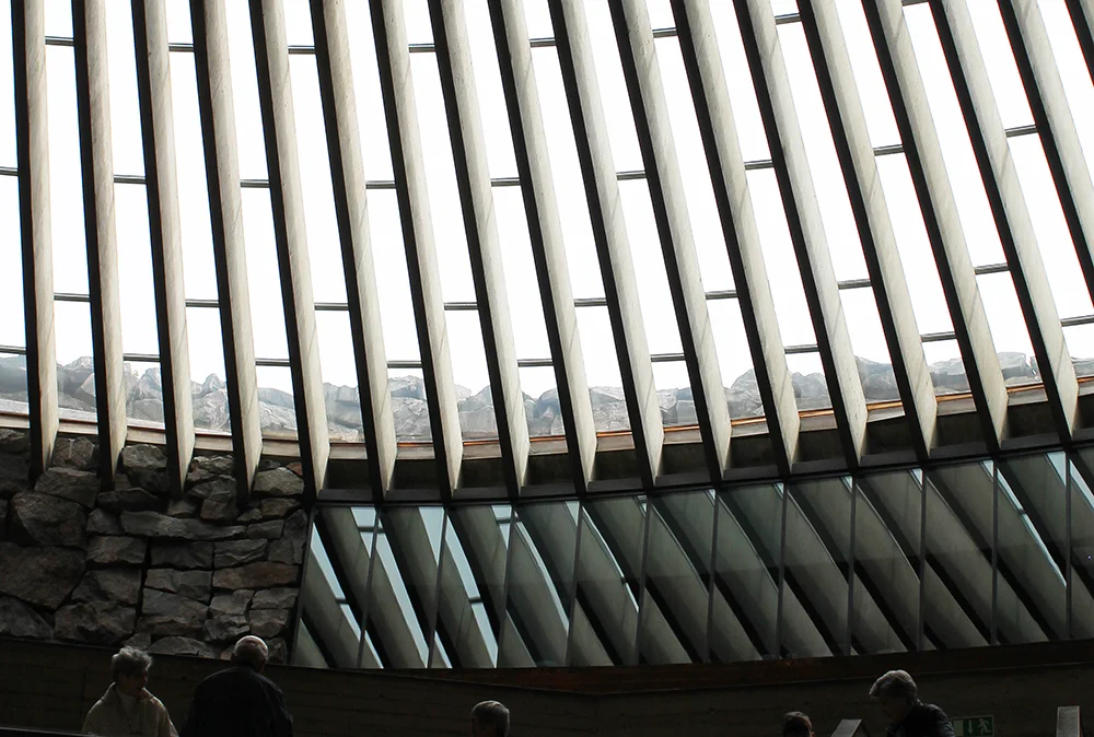 SPENNENDE ARKITEKTUR: Tempelplassens kirke er hugget ut i et berg, og når du går inn i den er det som å entre en grotte. Disse vinduene befinner seg bak alteret. Foto: Tenk Koffert