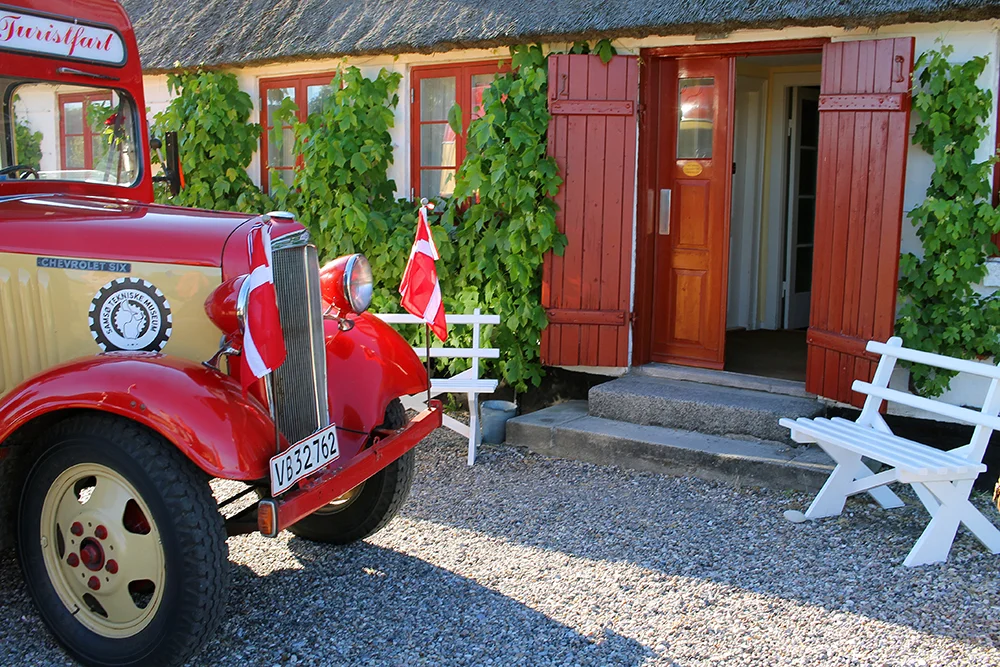 SAMSØ: Ønsker du å bli hentet på fergekaia i denne staselige bilen, er det én av måtene å komme seg rundt på Samsø på. Det er også grei bussforbindelse her. Velger du å sykle, koster det kr. 80,- per dag for sykkelleie. Det er også mulig å leie Elbil. Ta kontakt med Visit Samsø for mer info om dette. Foto: Tenk Koffert
