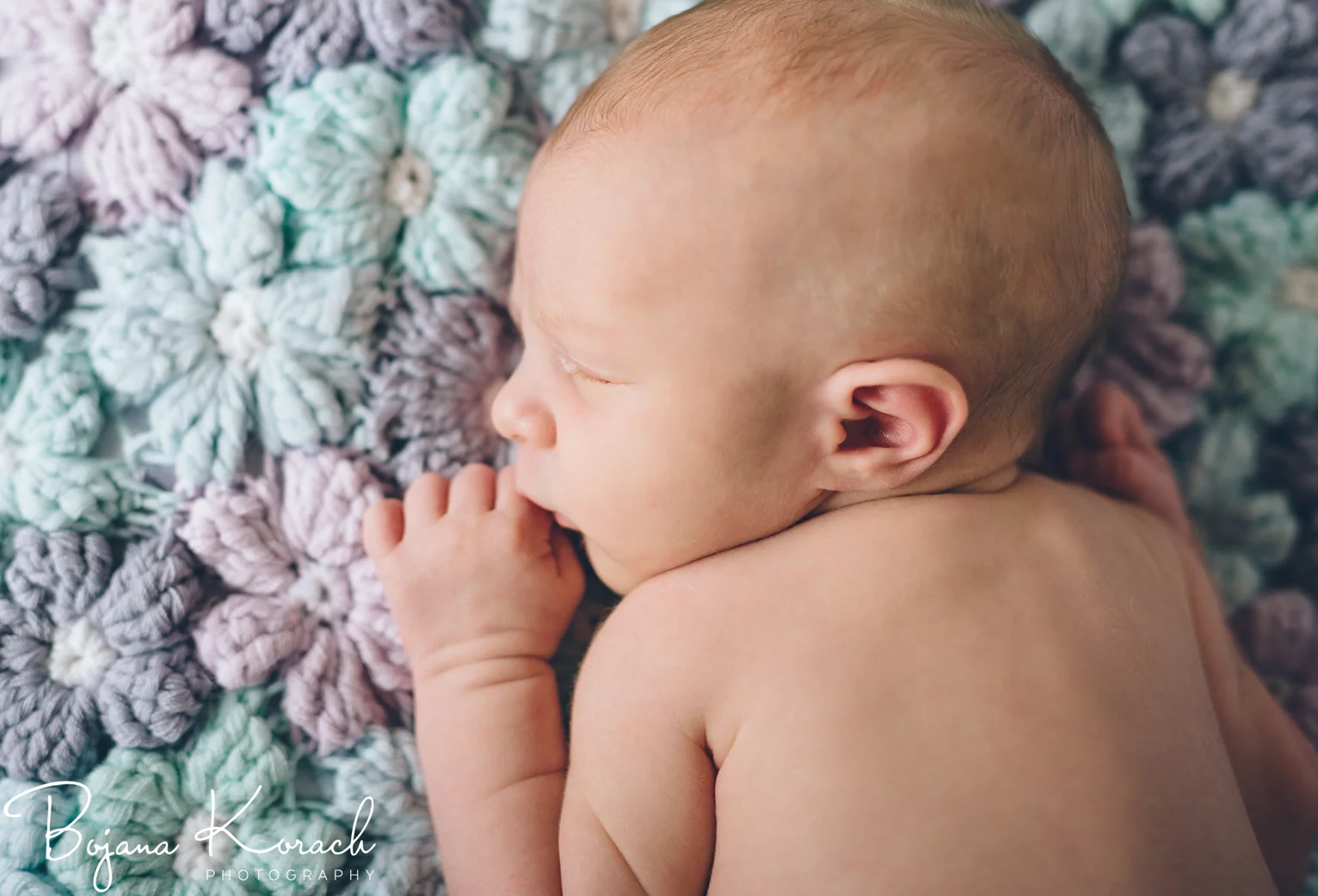 newborn baby girl with hand knitted blanket
