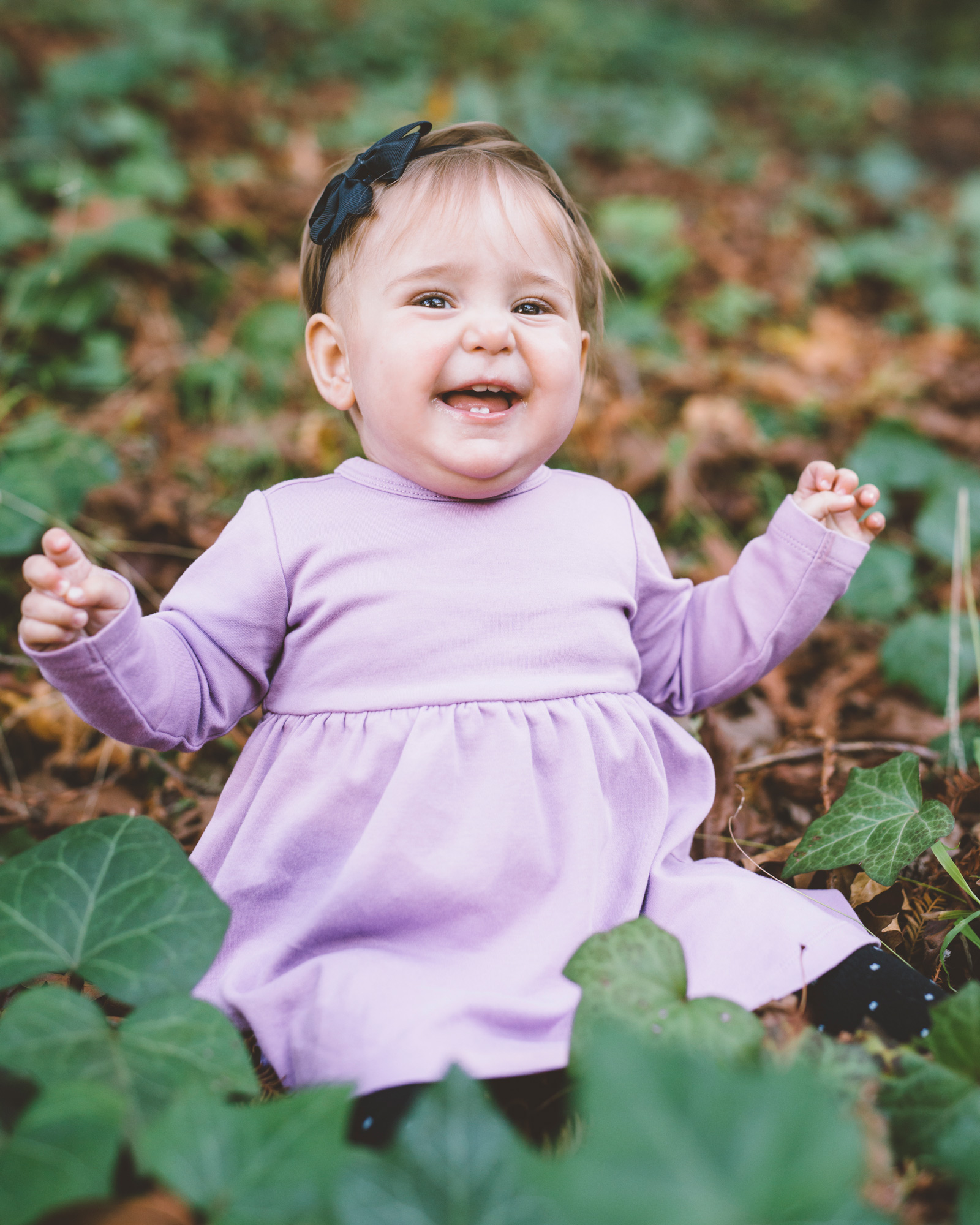 baby-girl-sitting-in-the-ivy-and-smiling.jpg