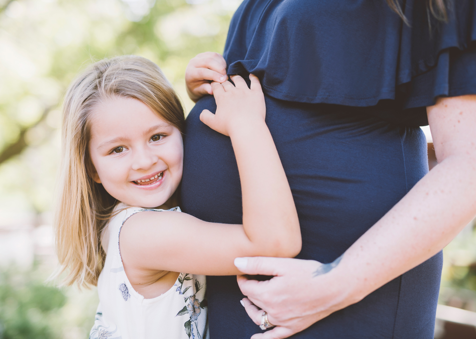 big-sister-hugging-mother's-pregnant-belly.jpg