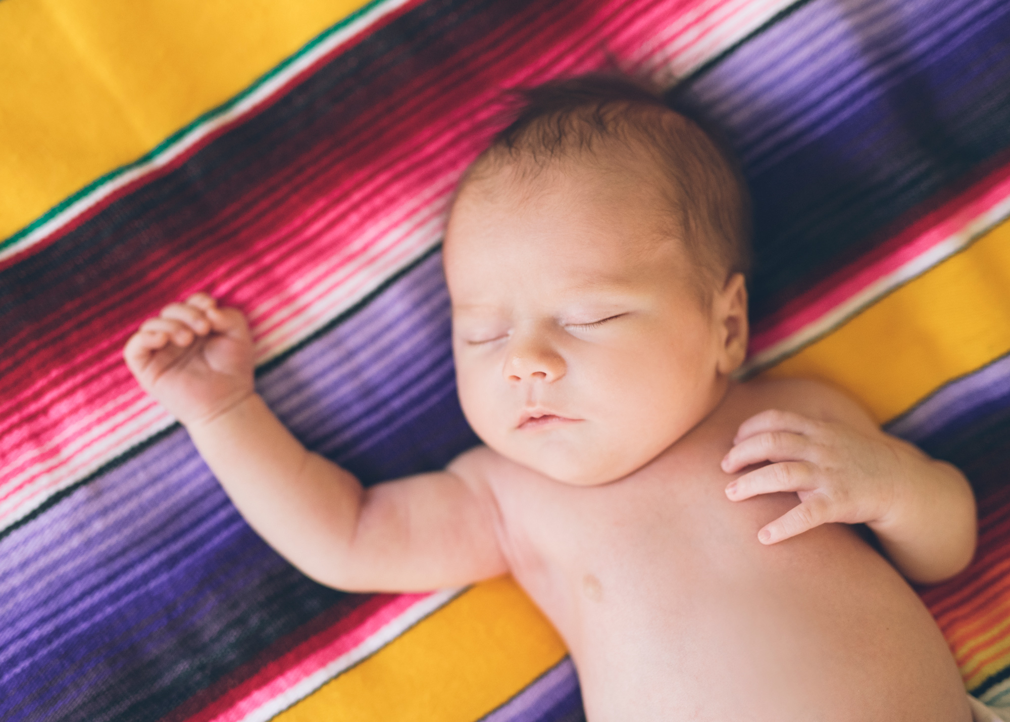sleepy-newborn-on-a-colorful-blanket.jpg