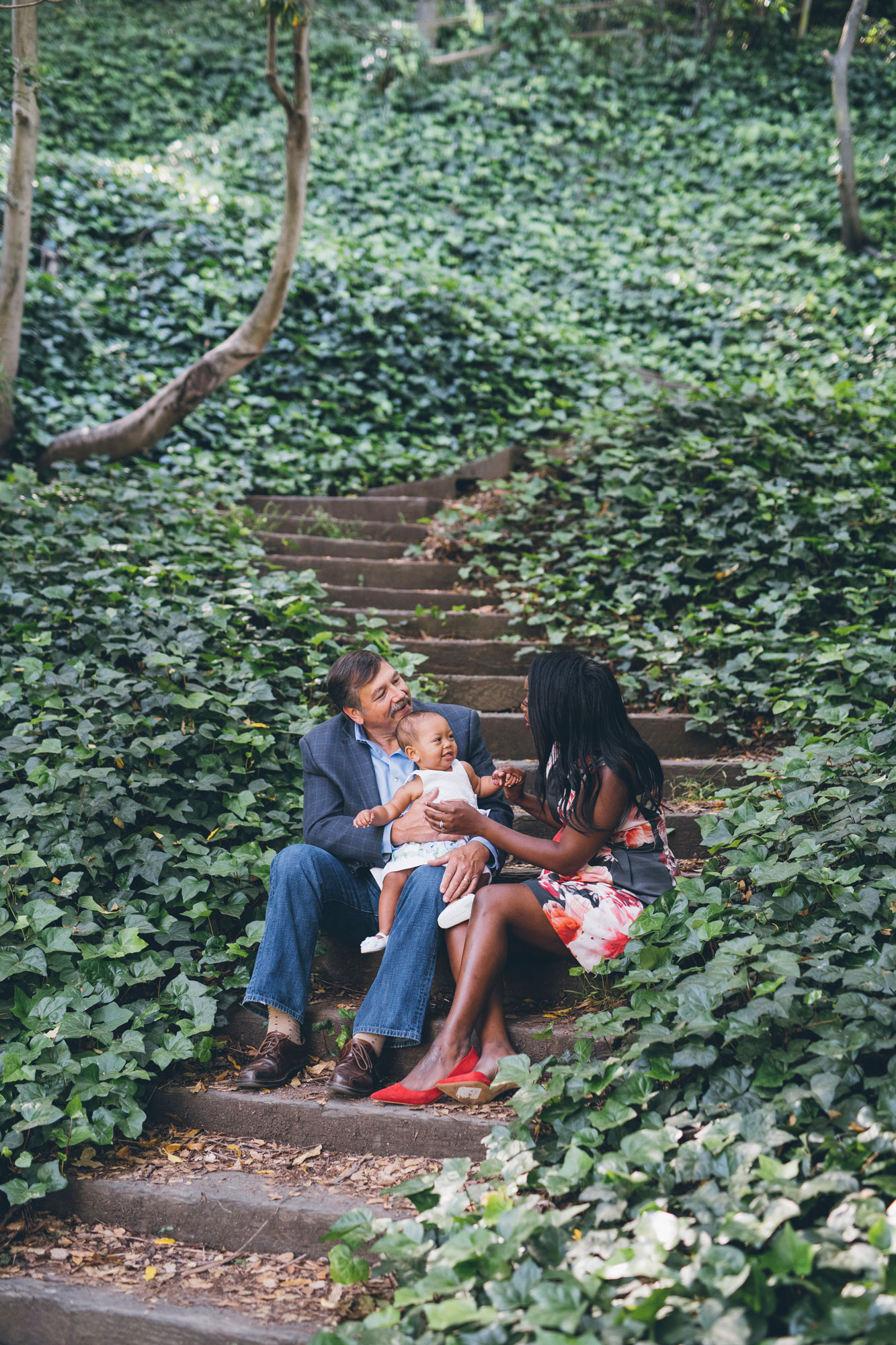 family-of-three-sitting-on-wooden-steps-in-the-wooded-area.jpg