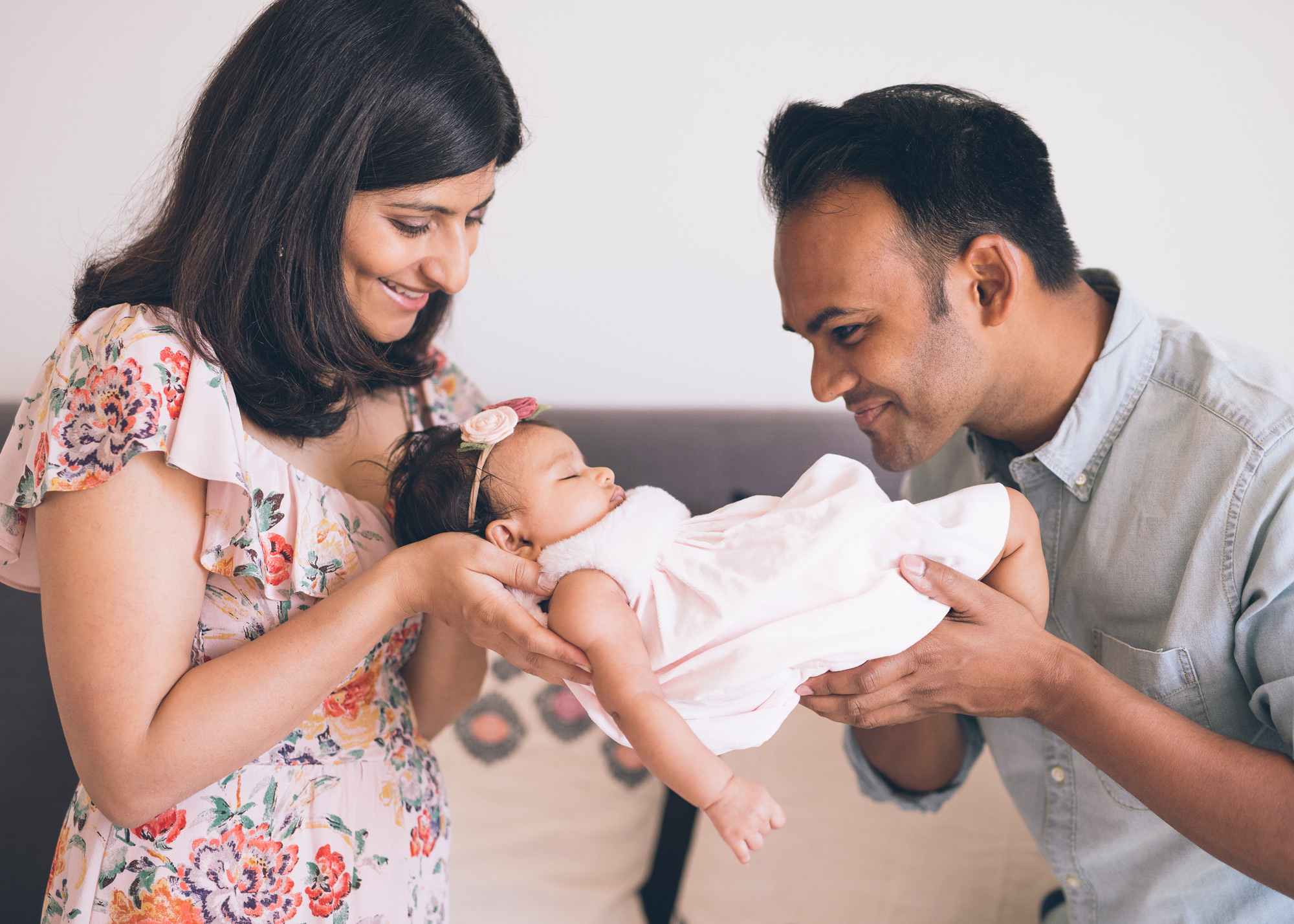 two-parents-holding-their-sleepy-baby-girl-in-their-hands.jpg