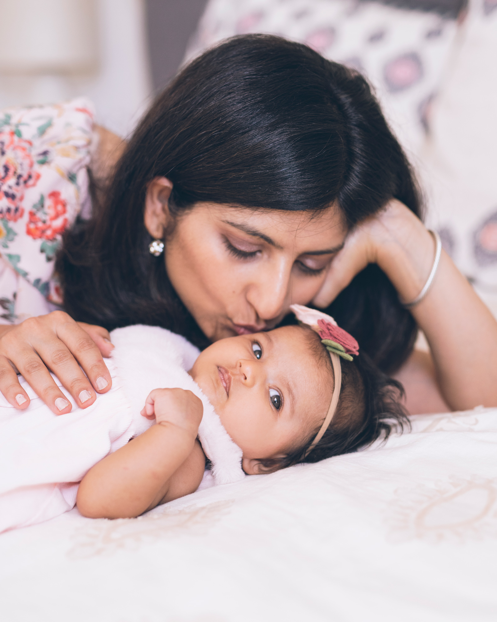 mother-kissing-her-baby-girl-softly-in-the-bed.jpg