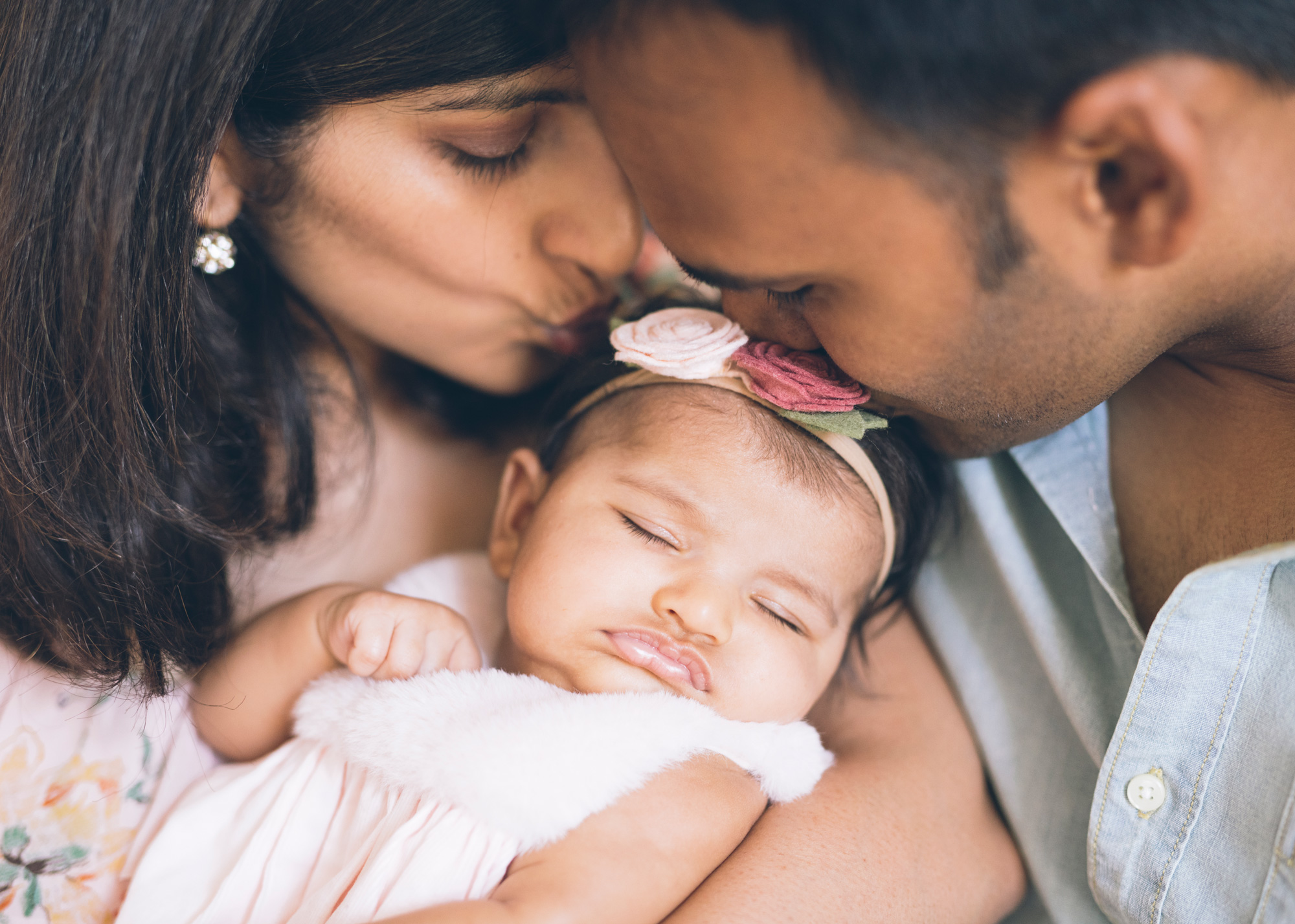 close-up-portrait-of-parents-kissing-their-beautiful-baby-girl.jpg