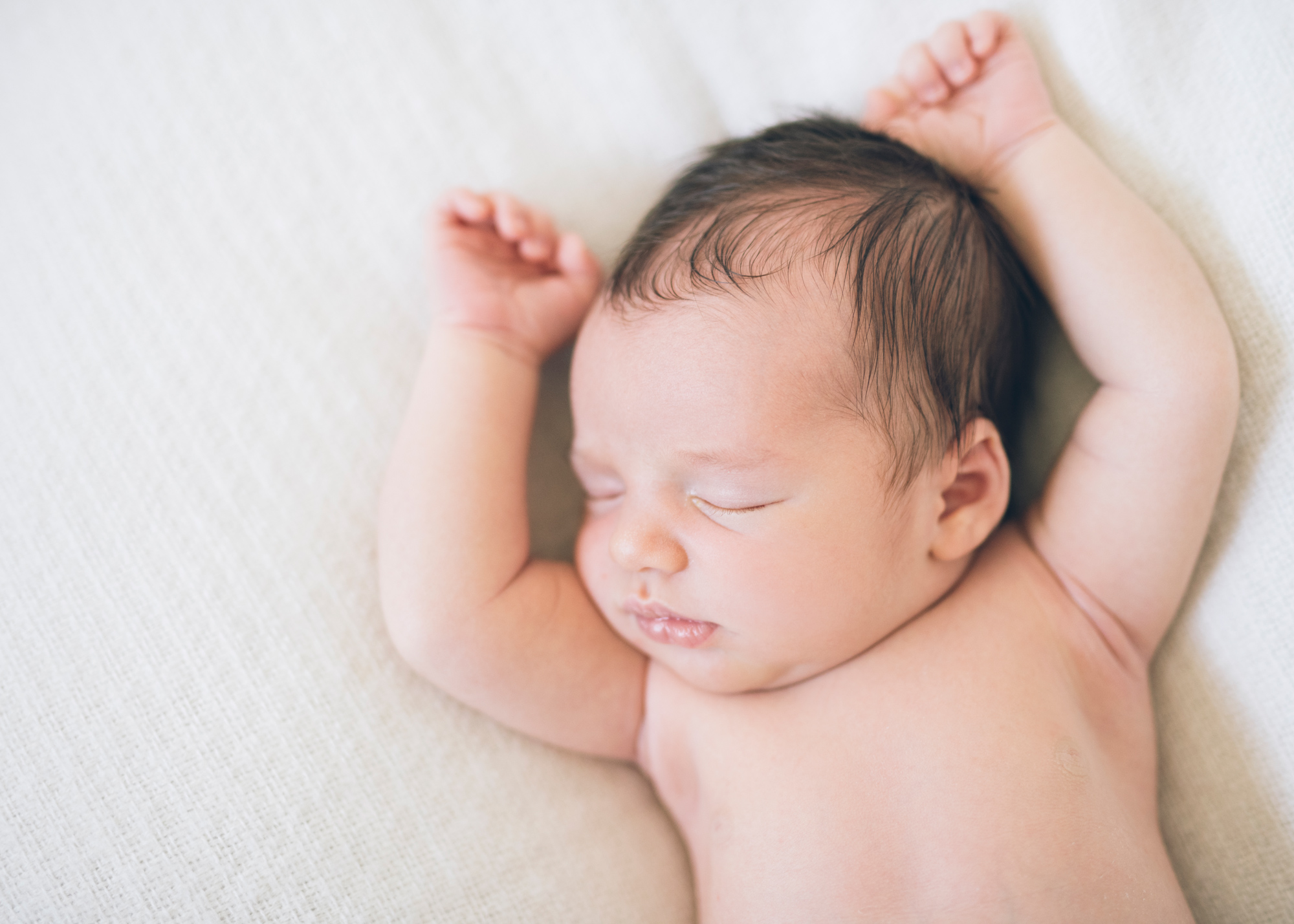 newborn-baby-boy-sleeping-witih-his-arms-up.jpg