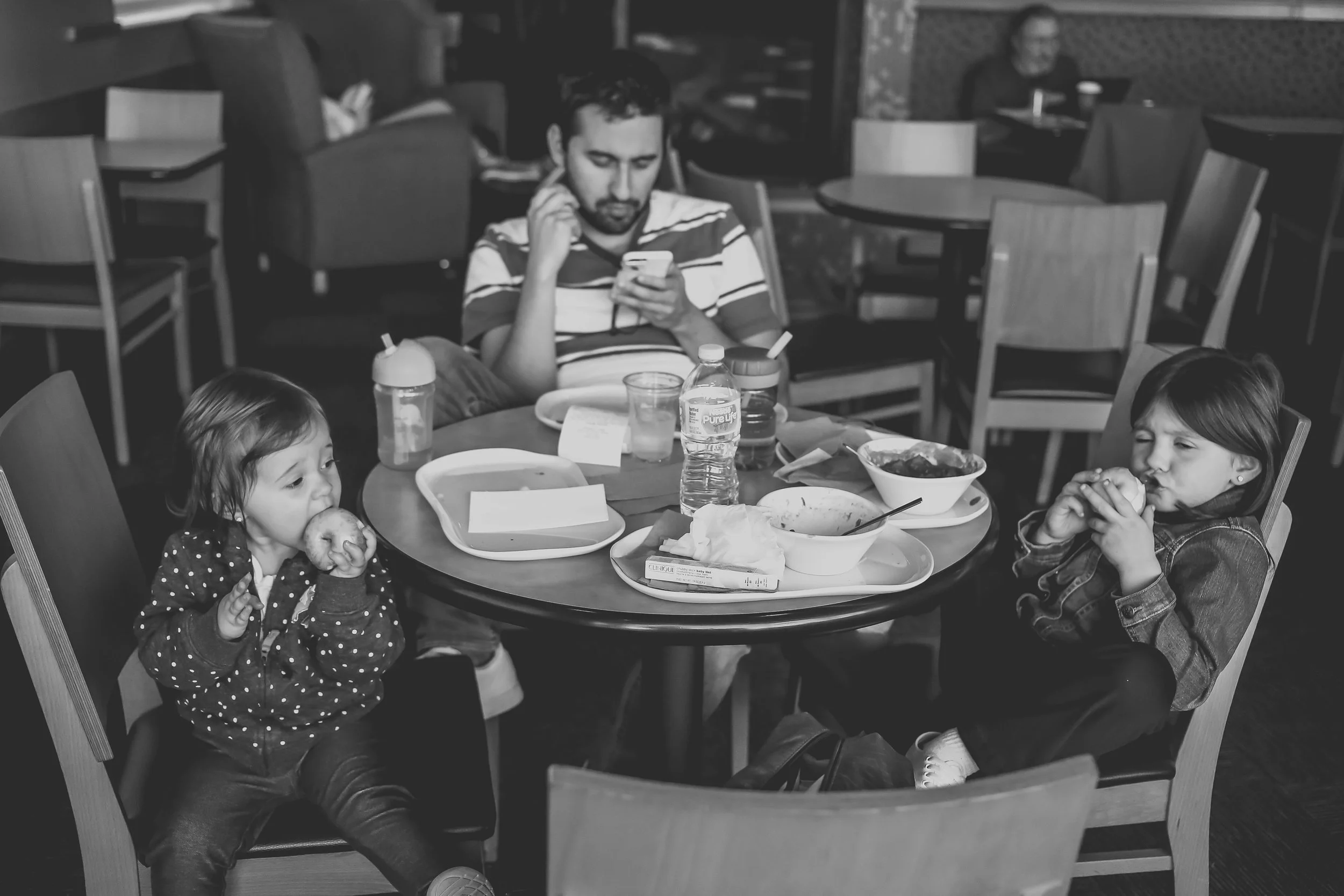 Father and daughters eating lunch at Panera Bread in Staten Island, NY. Documentary family photography.