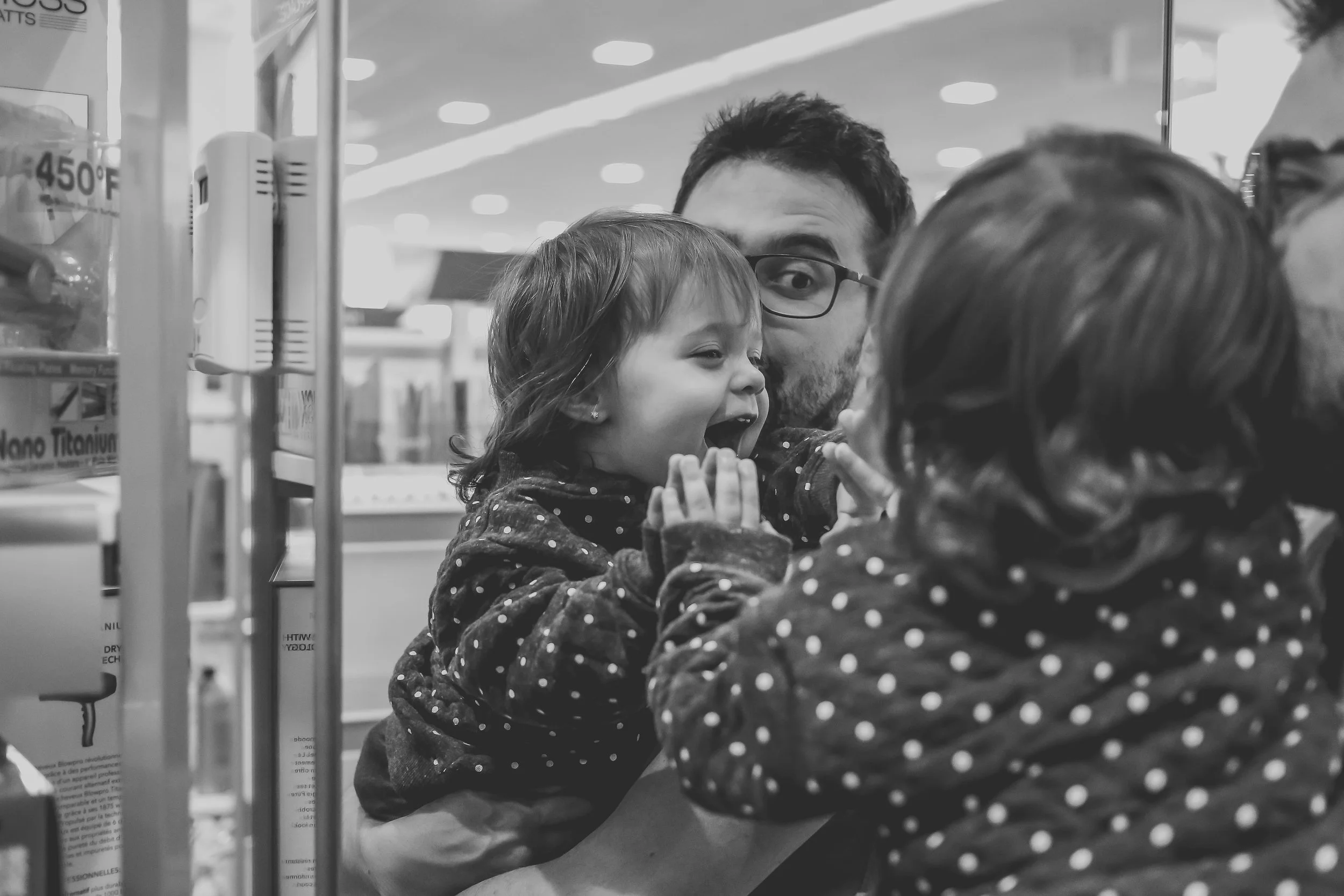 Playing in the mirror at Ulta beauty supply store in Staten Island, NY. Storytelling Family Photography.