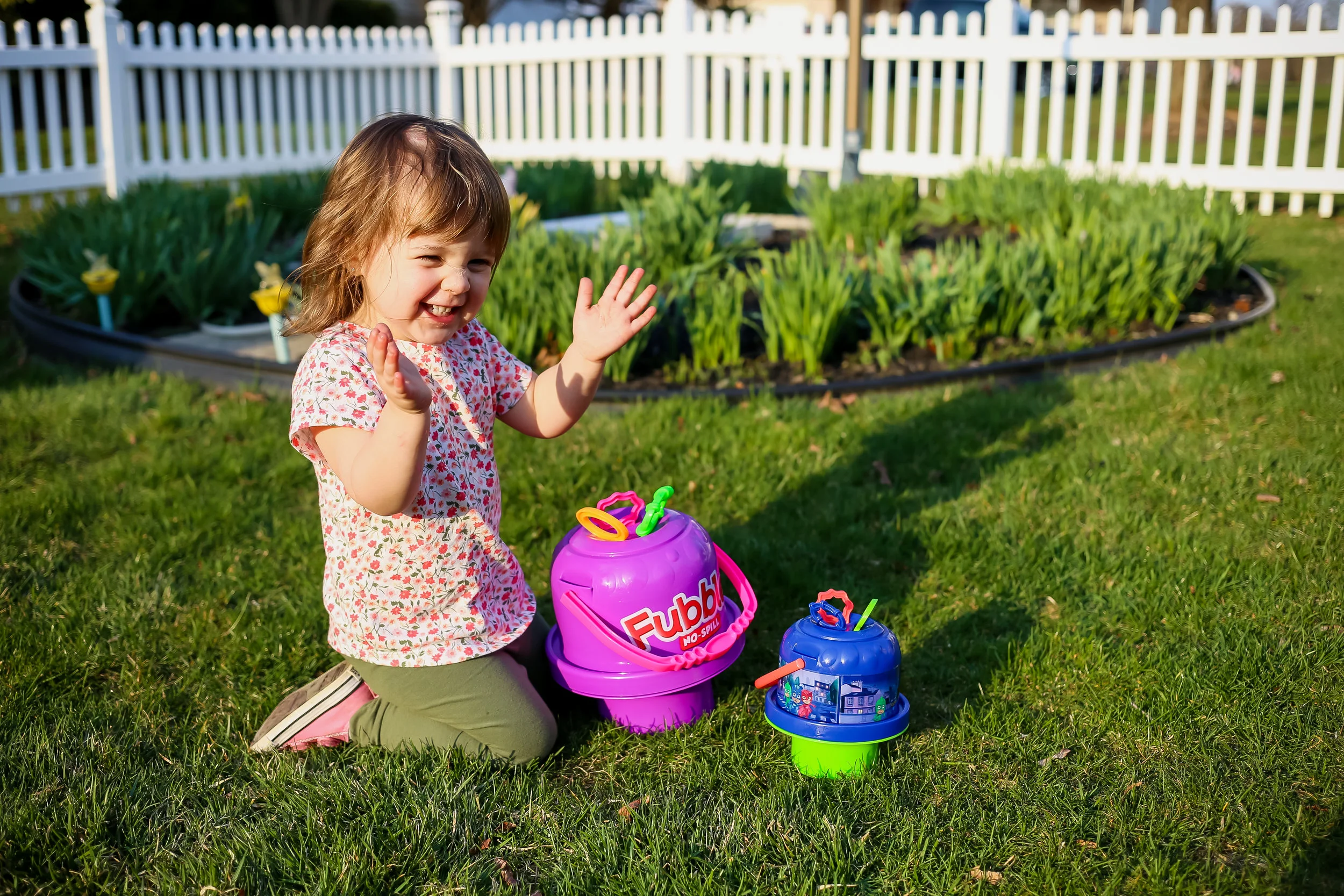Toddler girl playing with bubbles during a backyard family photo session in Lehigh Valley, Pennsylvania.