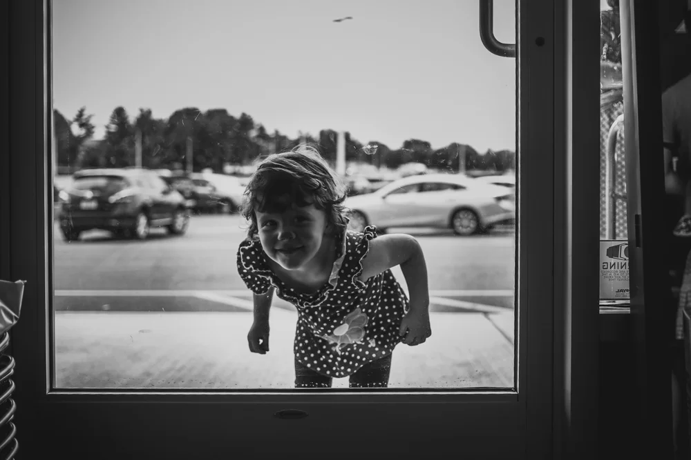 Little girl peering in from outside Ju-Ju Monkey in Allentown, PA.