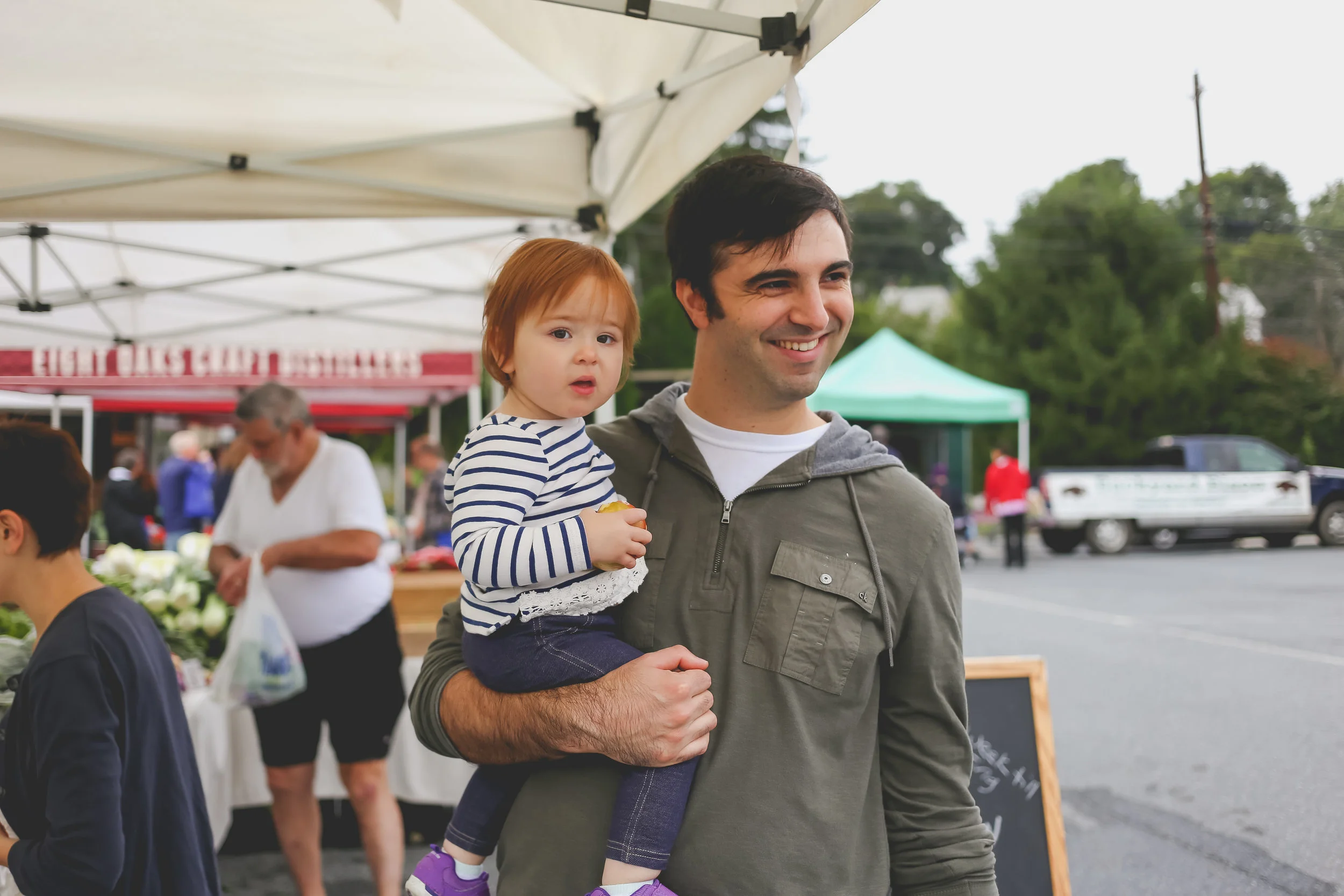 Father holding his baby daughter at the farmer's market in Emmaus, PA.