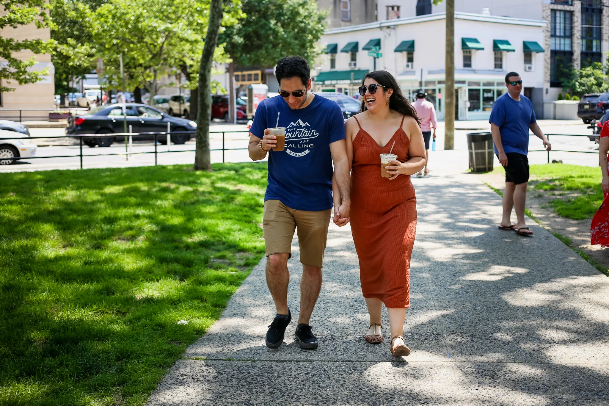 Walking through the park with iced coffee during their documentary style engagement photo session with Jen Grima, a Lehigh Valley photographer.