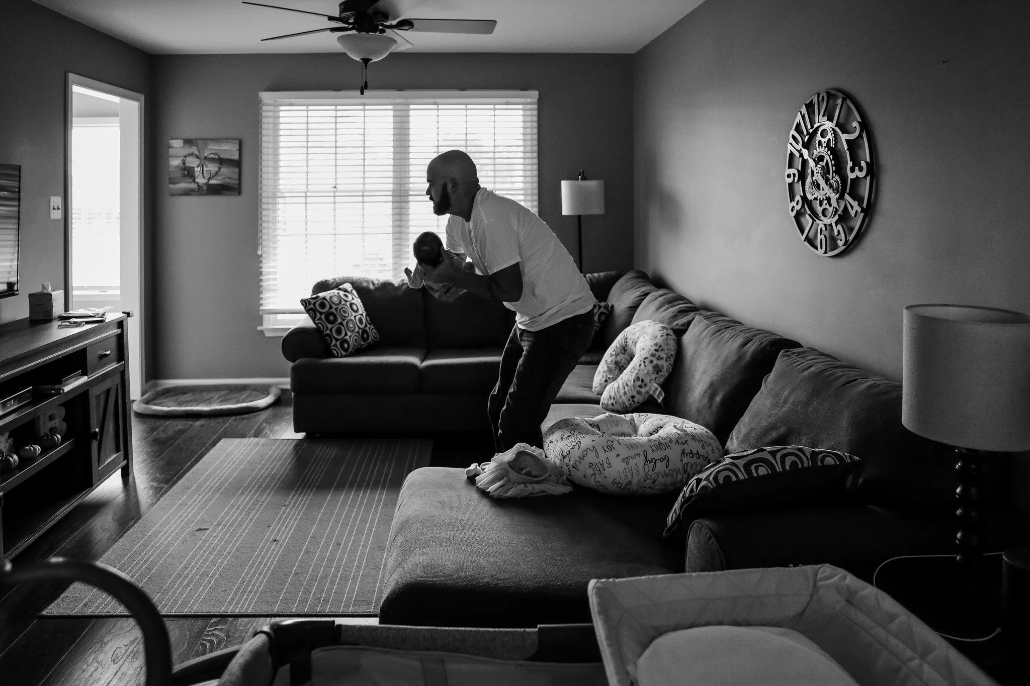 Father picking up his infant daughter during an at home family photography session in Lehigh Valley, Pennsylvania.